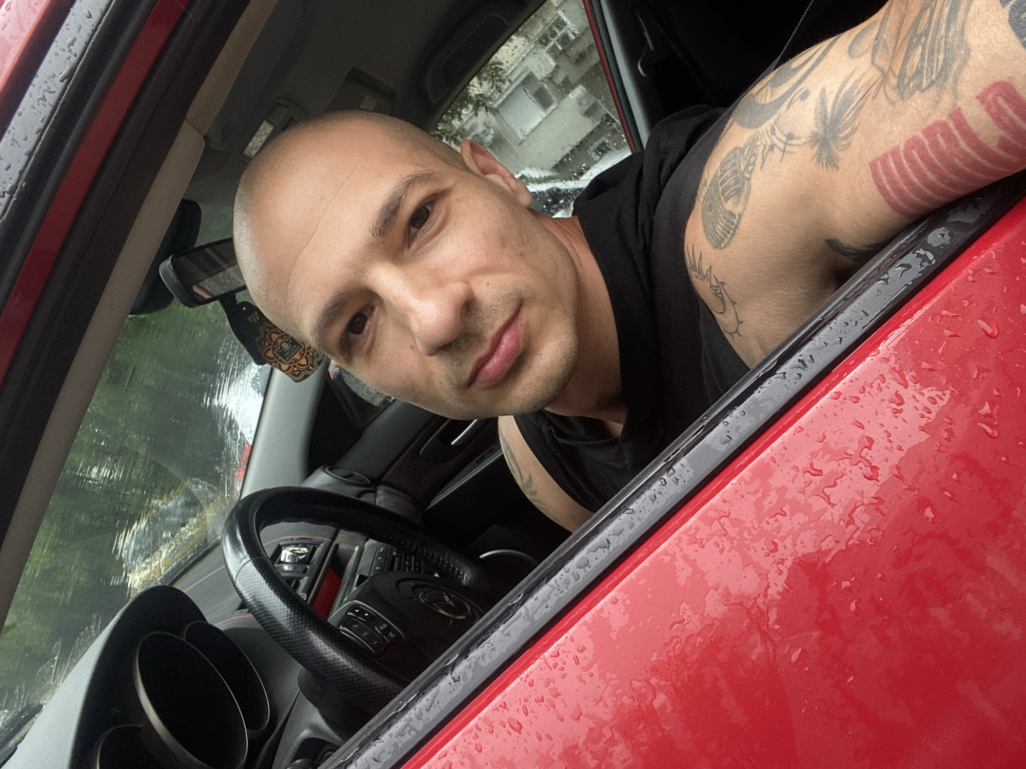 Man photographed twice in red car, outdoor selfie in Pleven