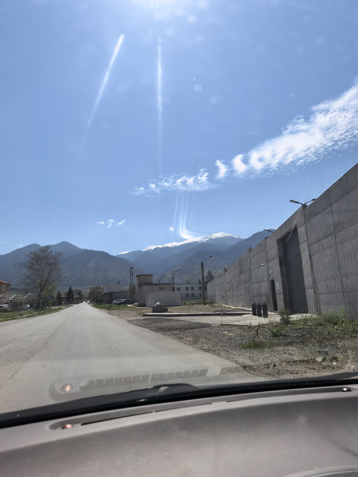 Driver documents sunny mountain road journey through rural countryside
