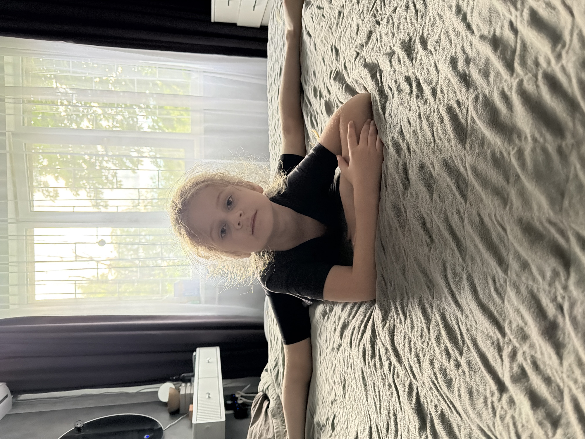 Person performs yoga poses and stretches on bed