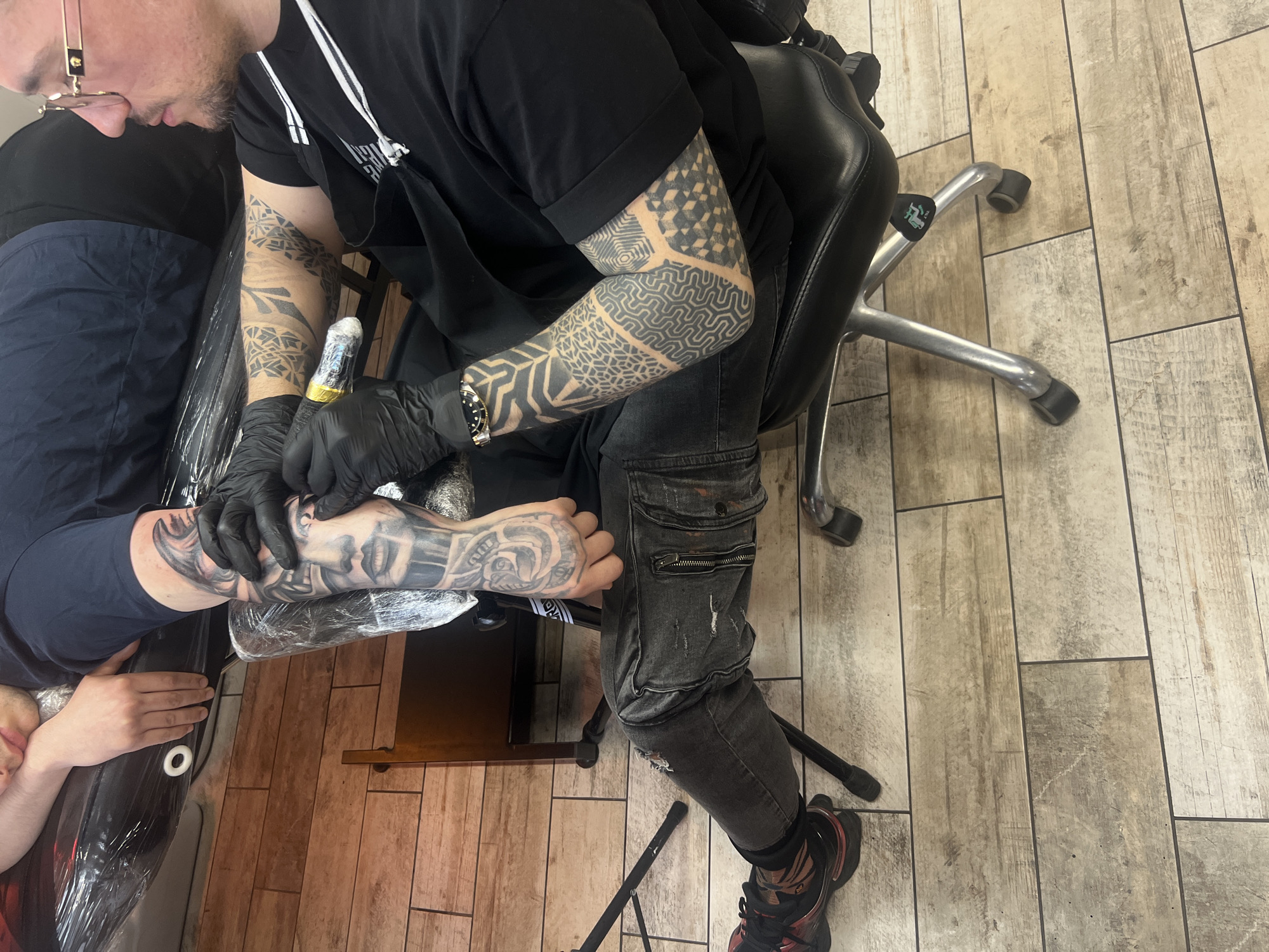 Tattoo session captured at Sofia parlor with neon decor