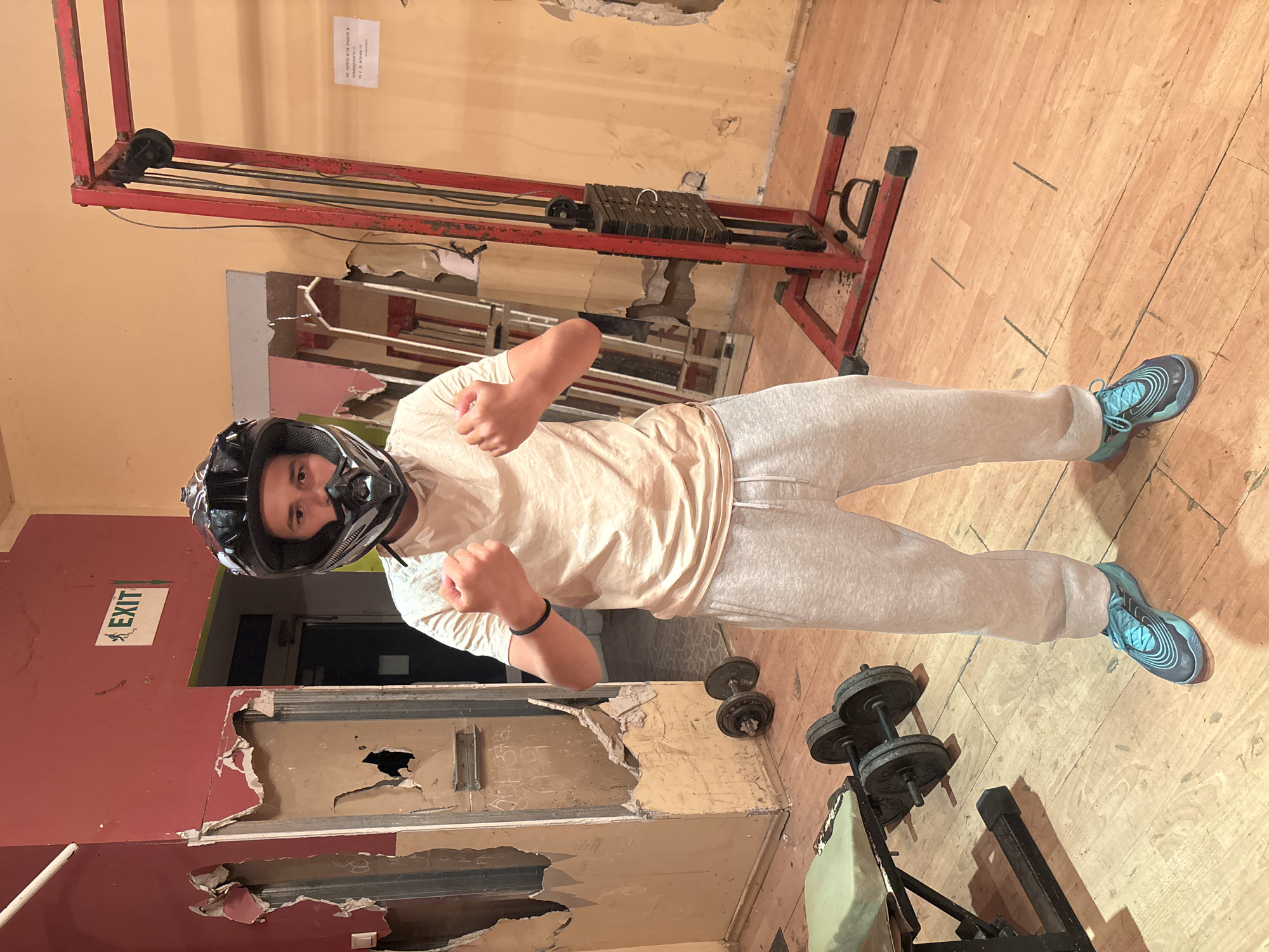 Helmeted person practices boxing in rundown Bulgarian gym