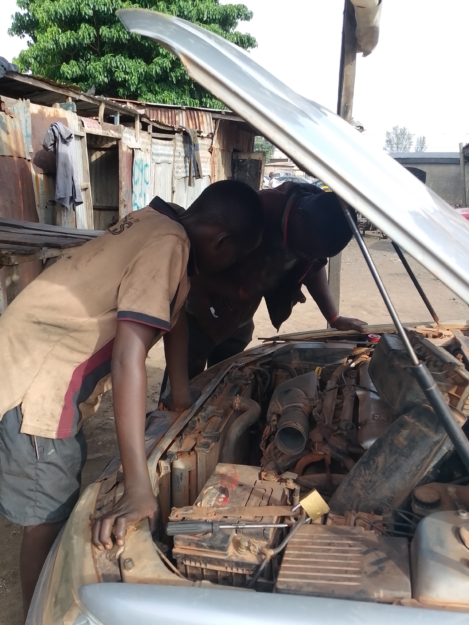 Two men repair car engine in Kakuri Gwari, Nigeria