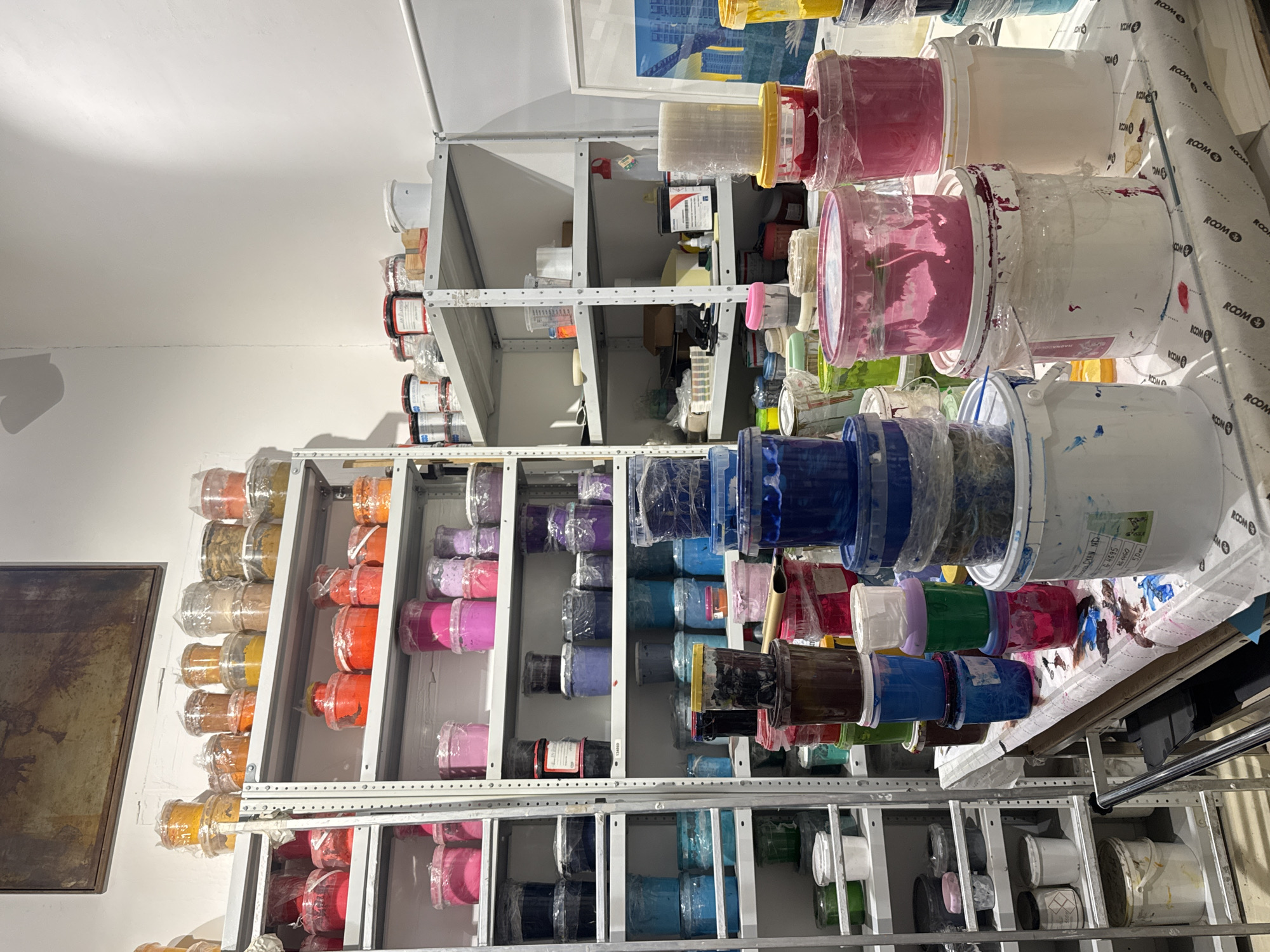 Storage room filled with colorful paint buckets documented