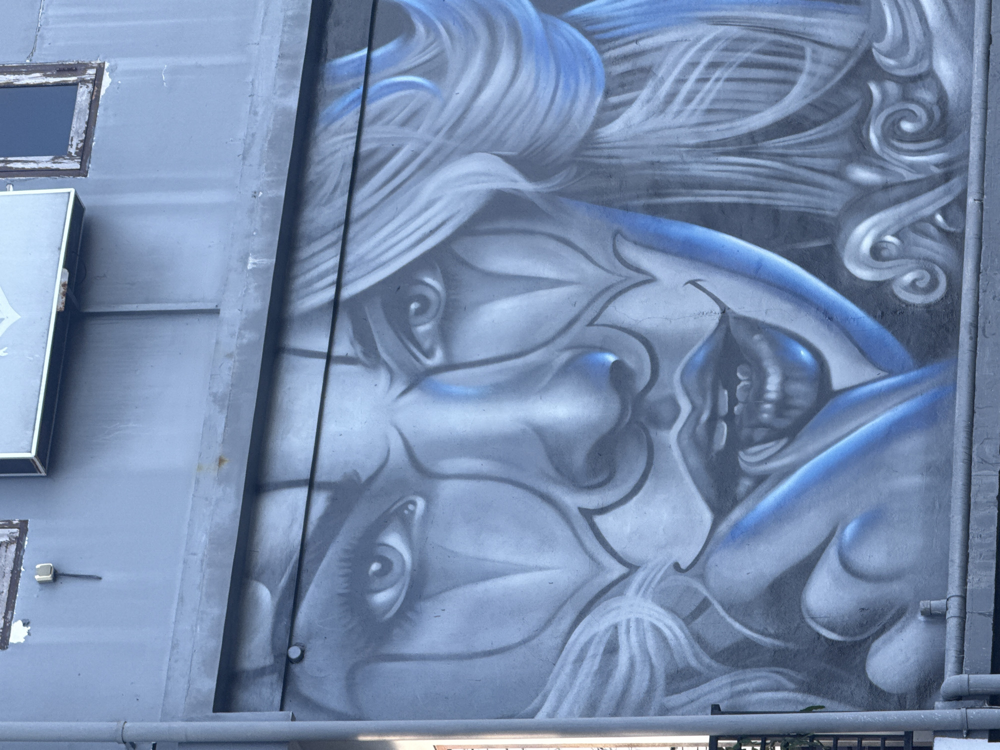 Blue and white face mural spotted on Kuta building