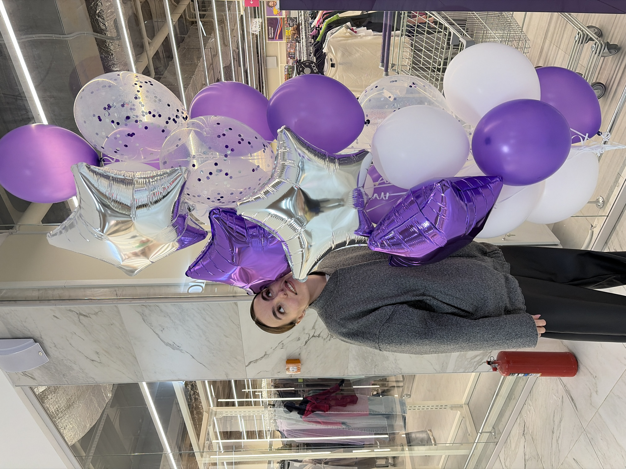 Person carries balloon bouquet in Izhevsk retail store