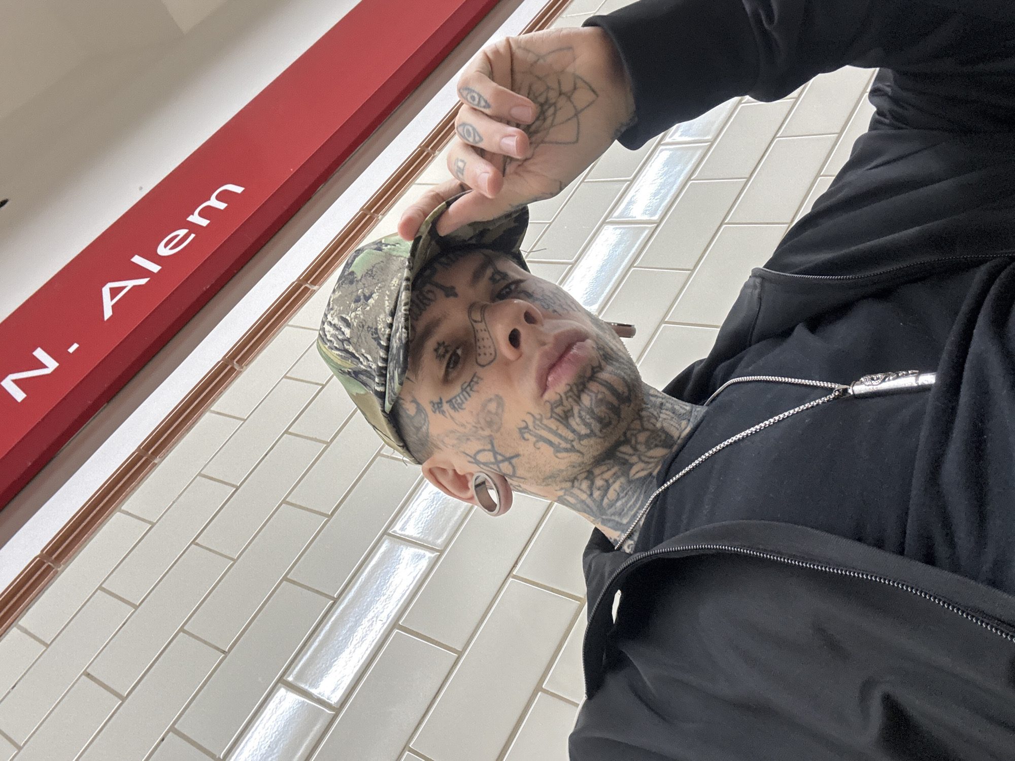 Tattooed Individual Photographed in Low-Angle Selfie in Buenos Aires
