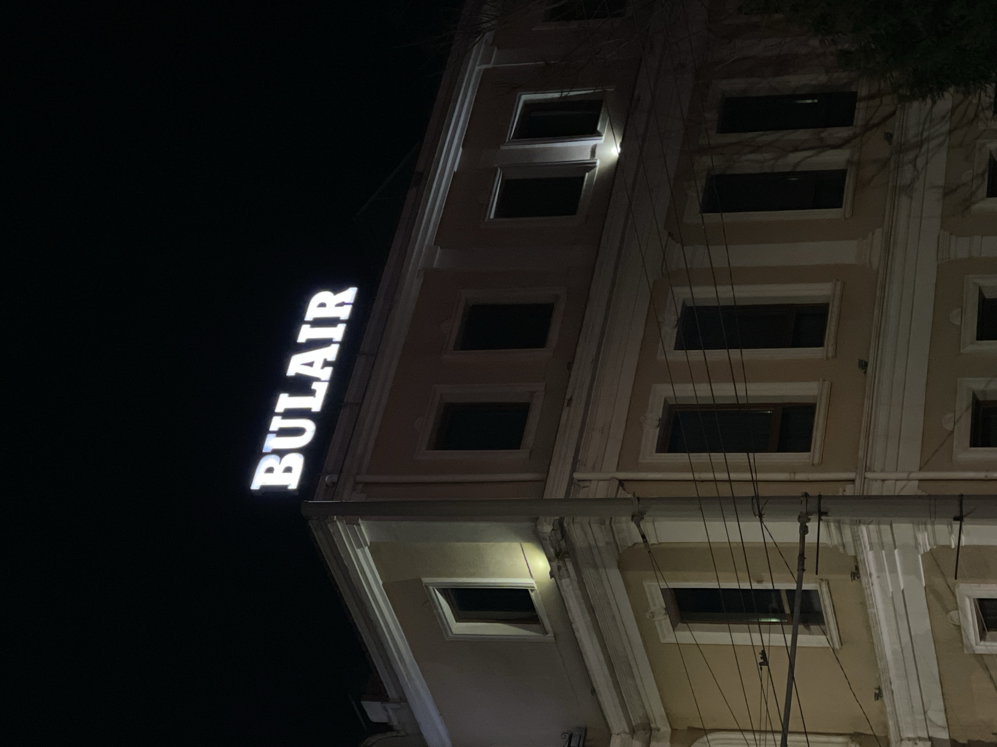 Illuminated building with BULAIR sign observed at night in Burgas