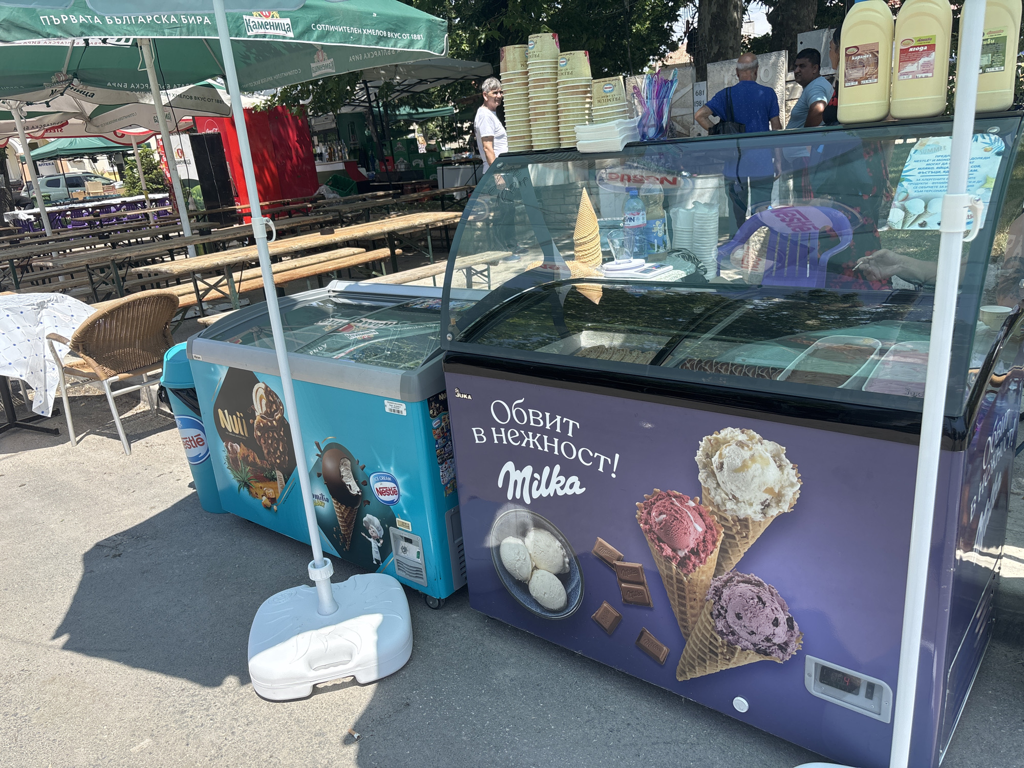 Ice cream vendors serve customers in sunny Kostievo market