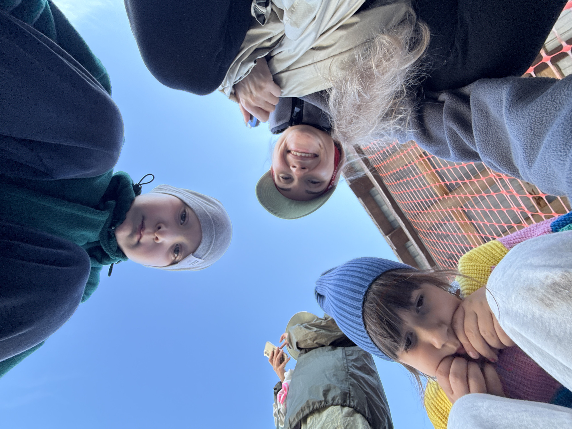 Looking up at faces against a blue Arctic sky in Teriberka