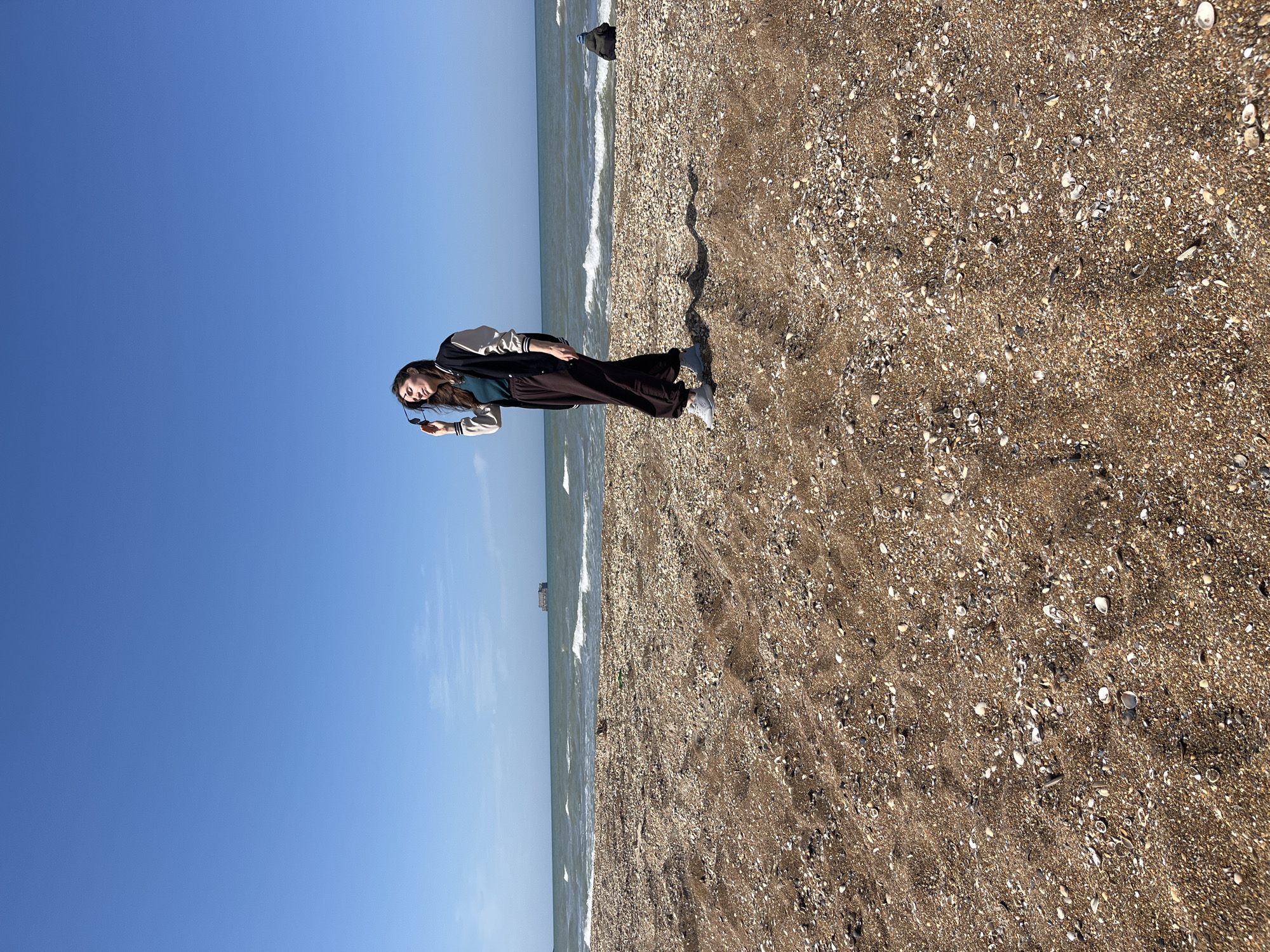 Woman stands on beach in Kaspiysk, Russia