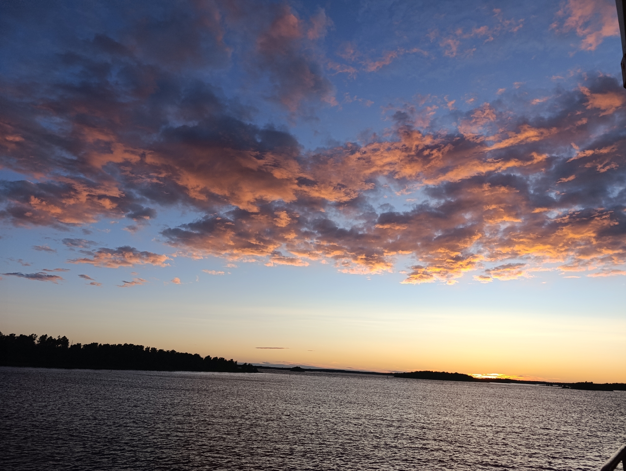 Sunset over the water, port facilities visible in one frame