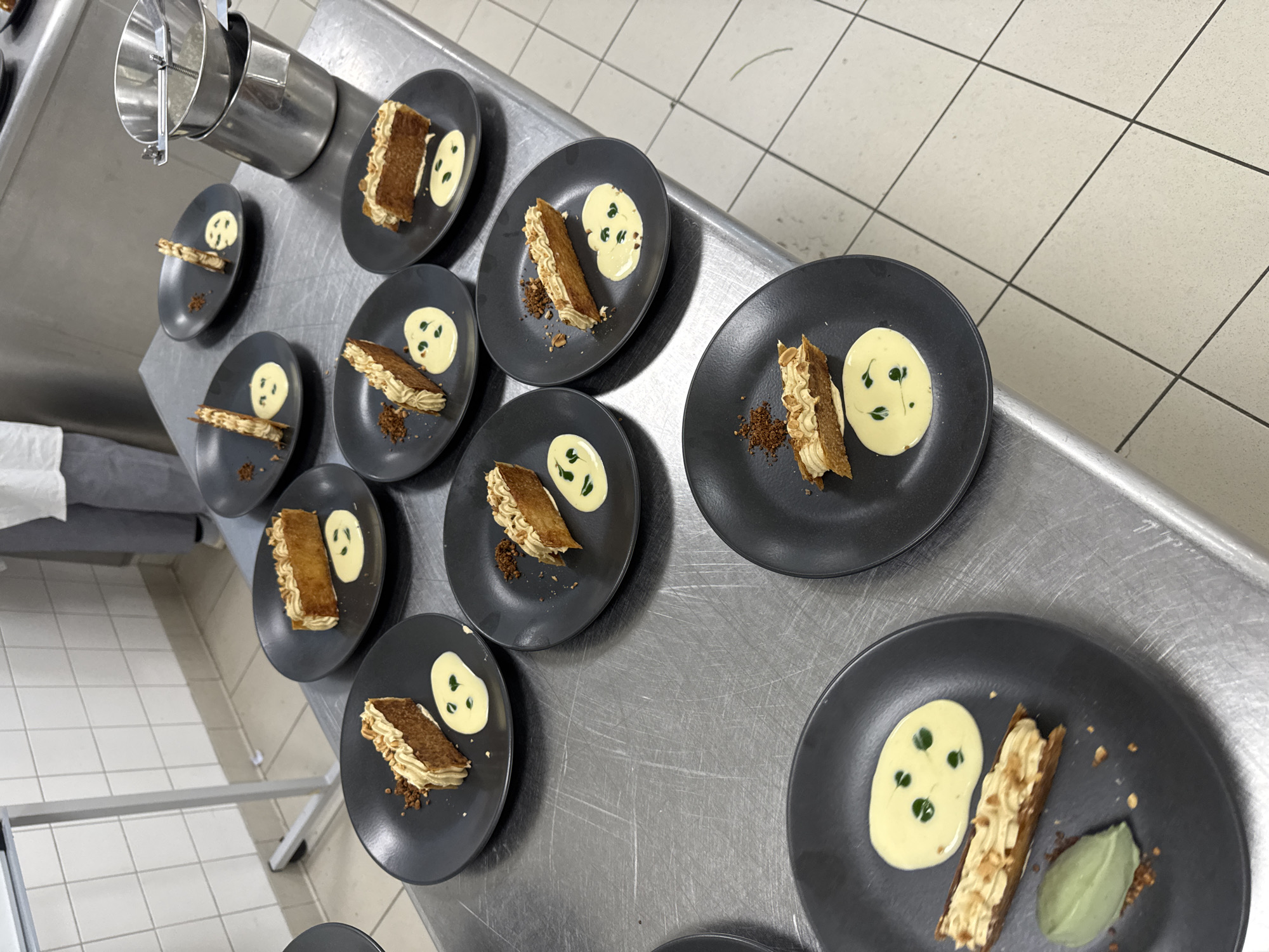 Chef prepares multiple plated dishes in Schiltigheim kitchen