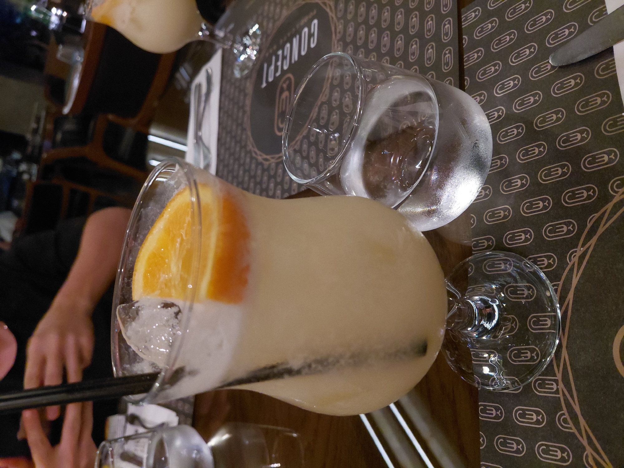 Woman documents evening restaurant meal with drinks and dessert