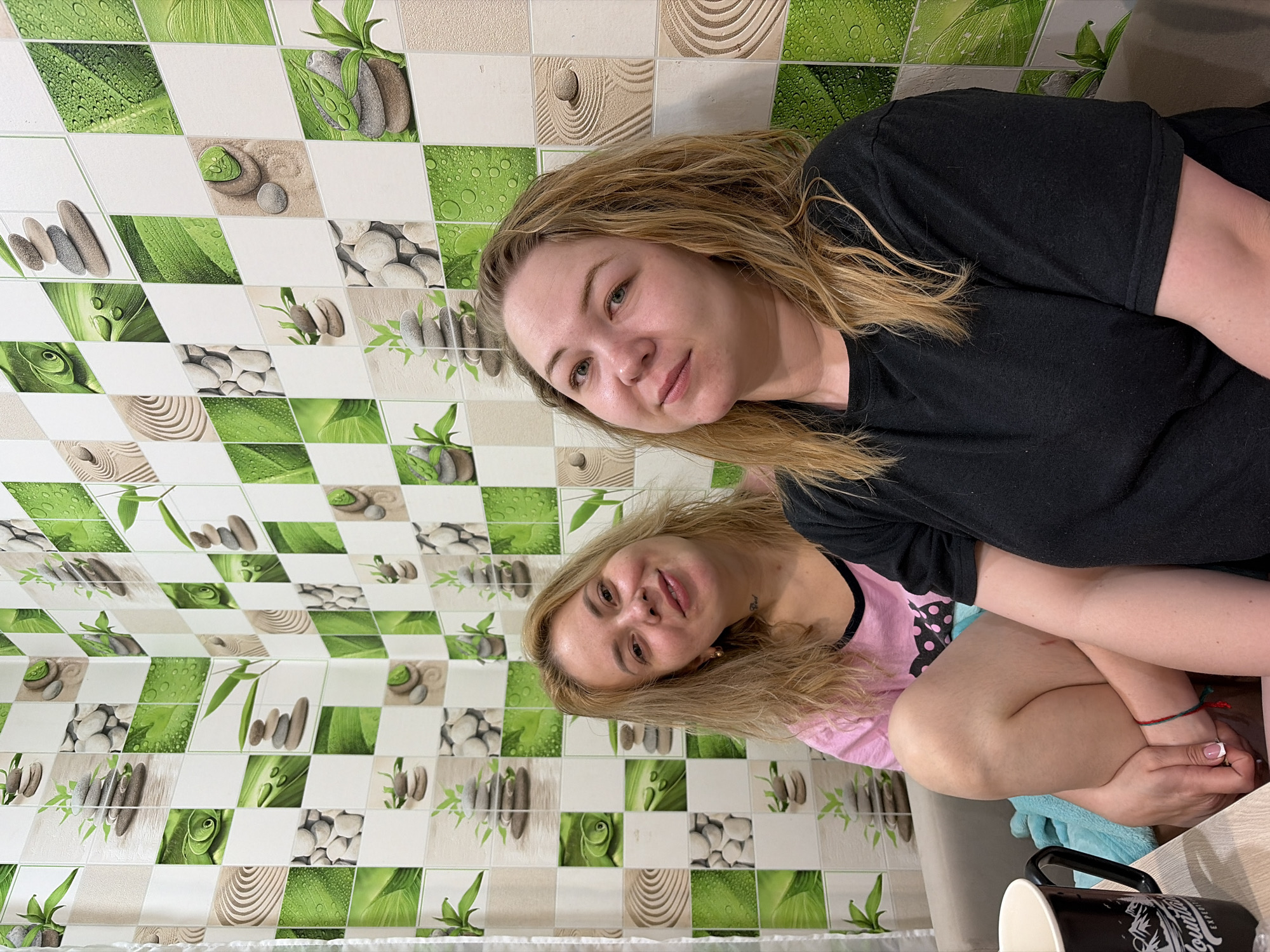 Two women photographed against decorative wall in Noviy, Russia