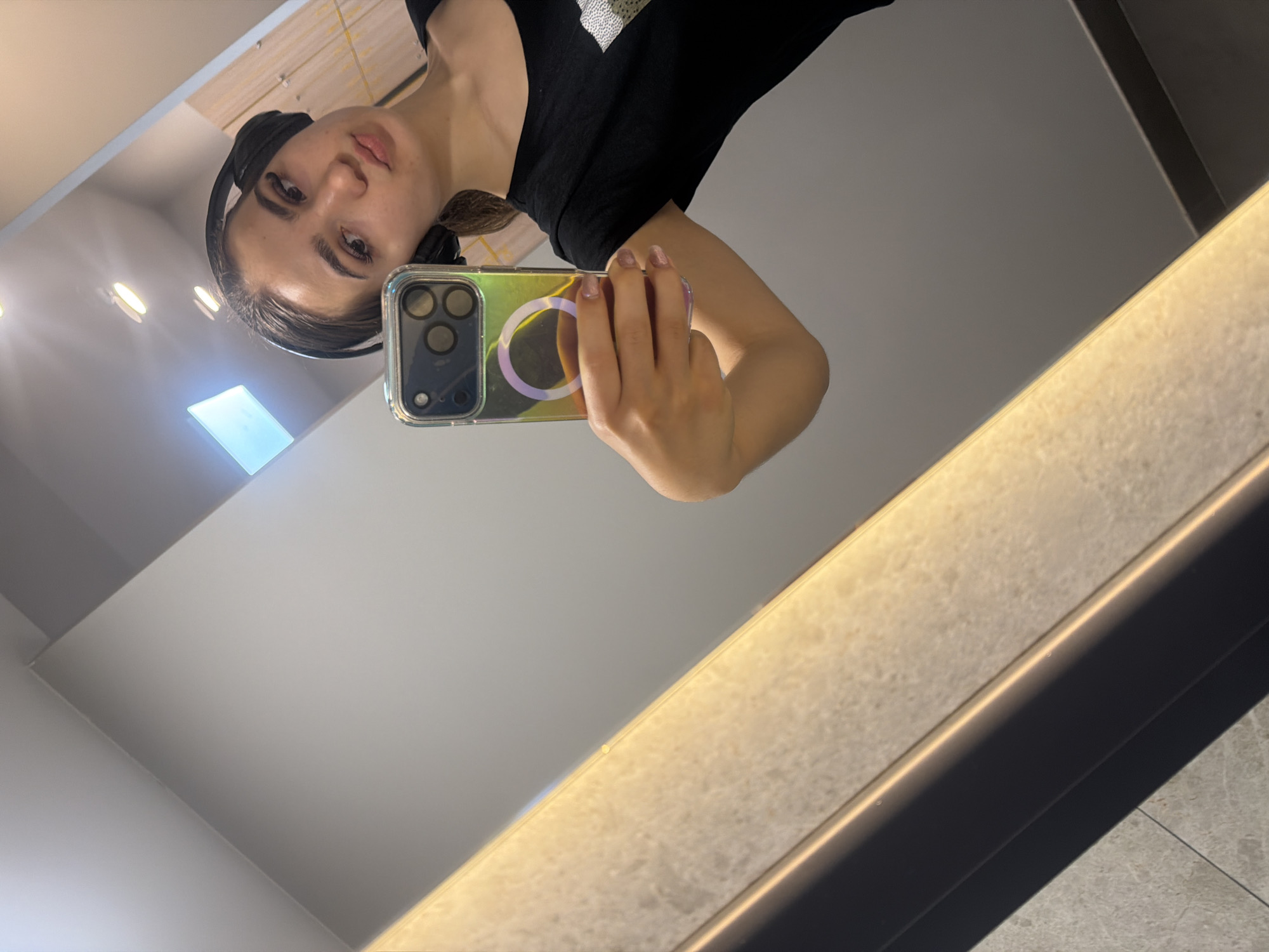 Woman takes mirror selfie with headphones in Sofia interior