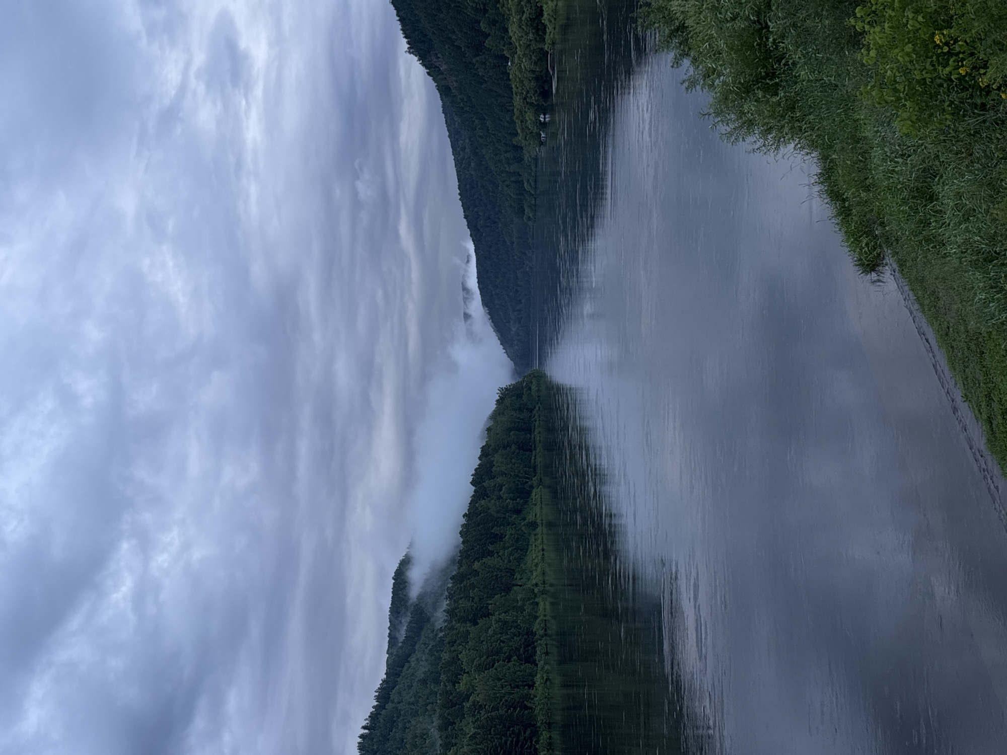 Misty river winds through forested hills in rural Siberia
