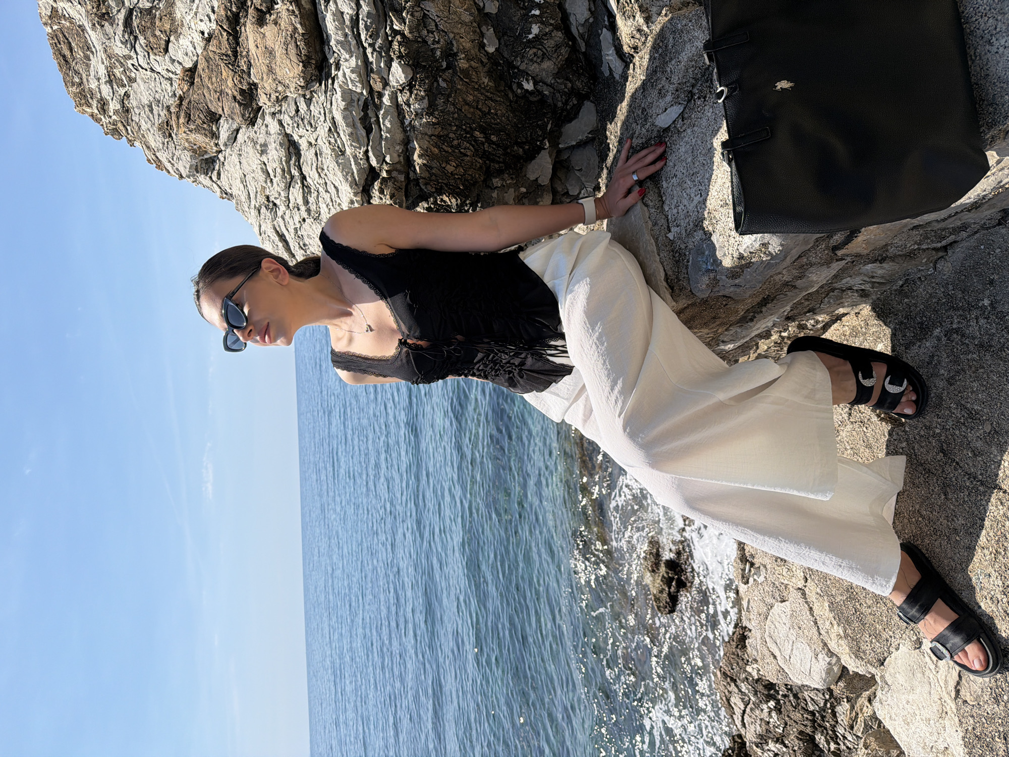 Woman poses for photos on sunny Budva coastline