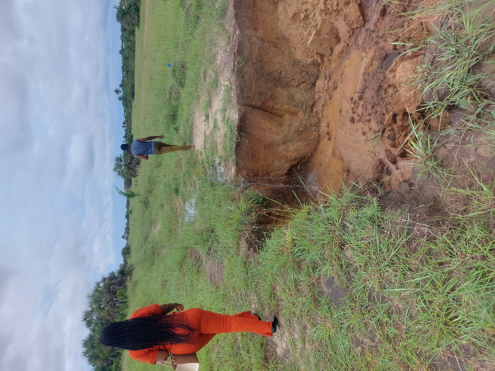 Two people examine phones in field near Dar es Salaam