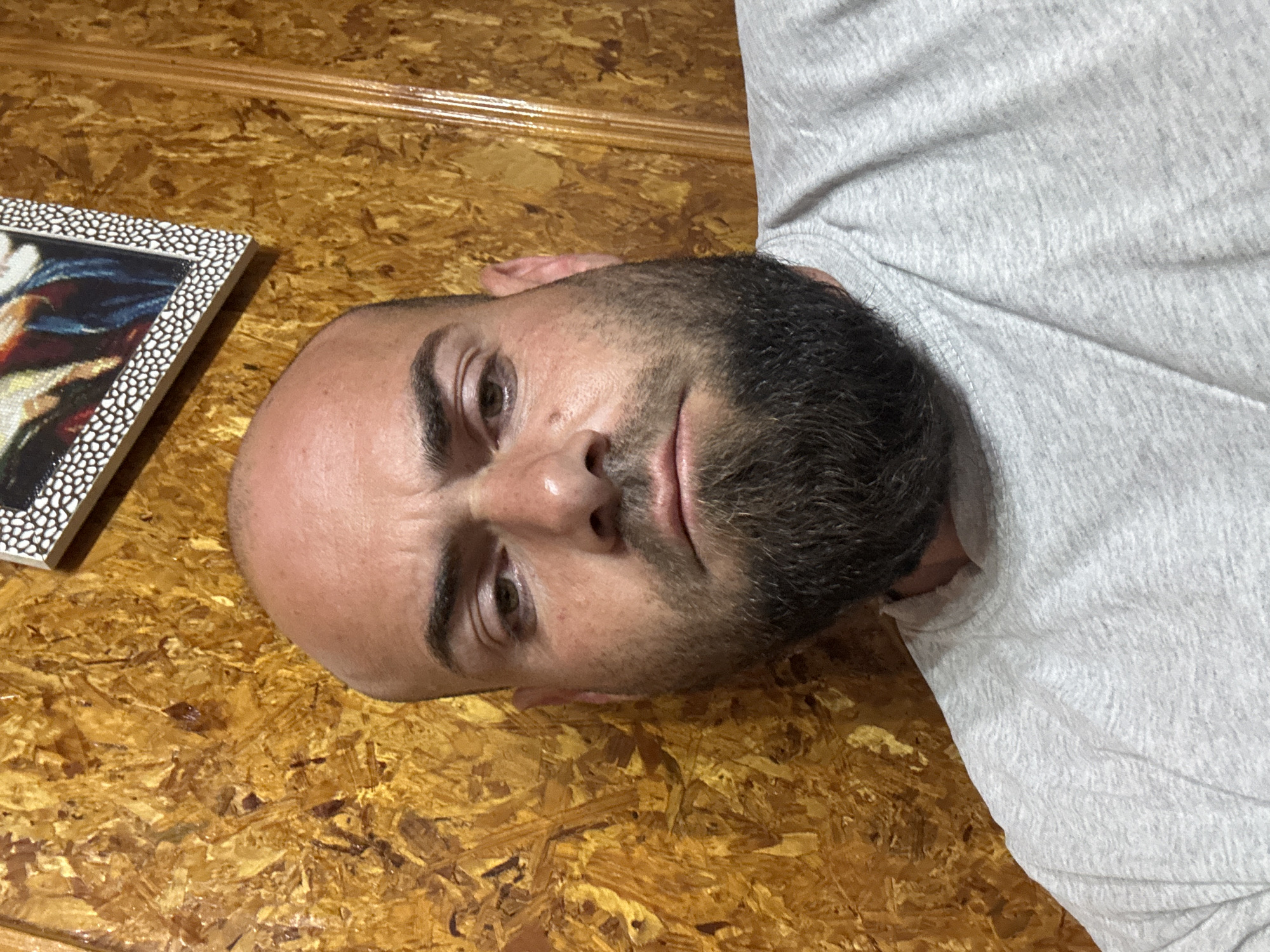 Man resting on wooden surface near artwork in Sarnevo