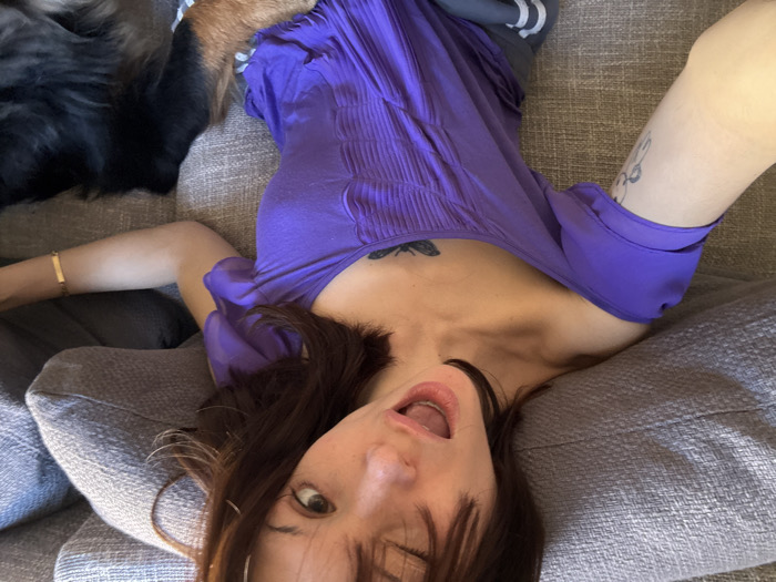 Woman and dog rest indoors, balcony view captured in Barcelona