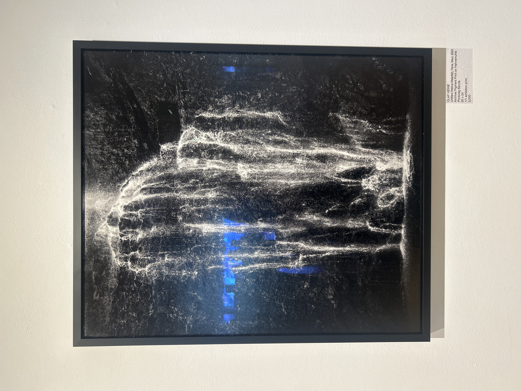 Late-night art viewing of water cascade photograph in West Hollywood