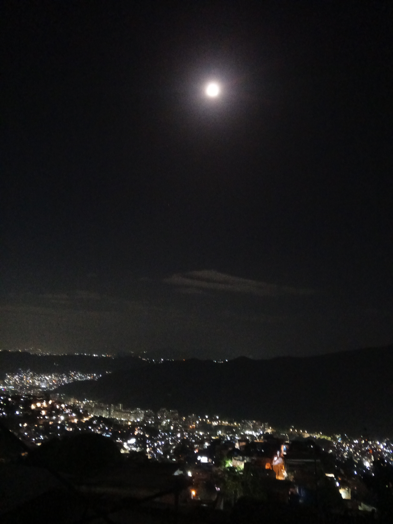Moonlit Caracas captured in nighttime observations across city valley