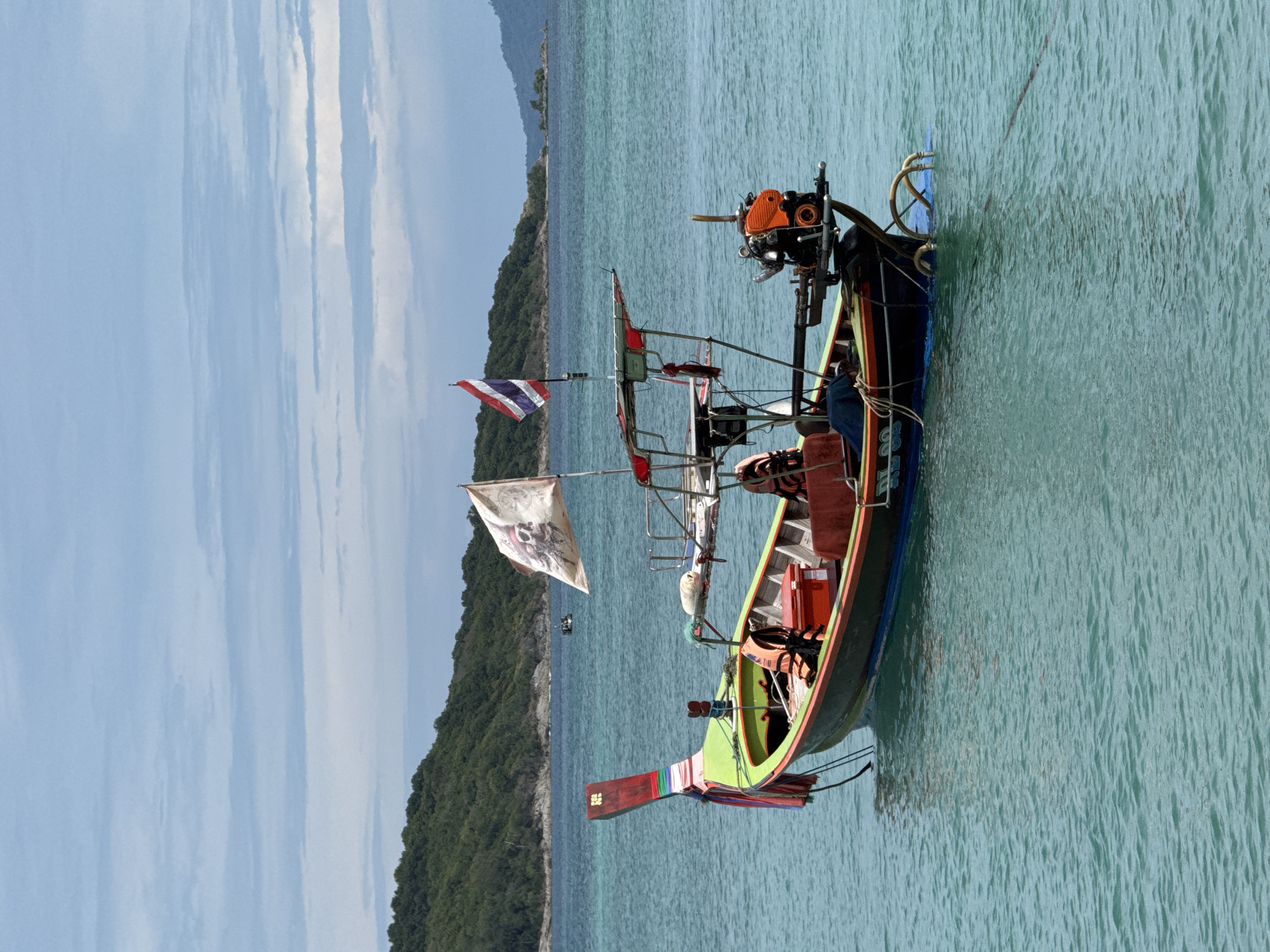 Longtail boats at rest in calm waters off Rawai