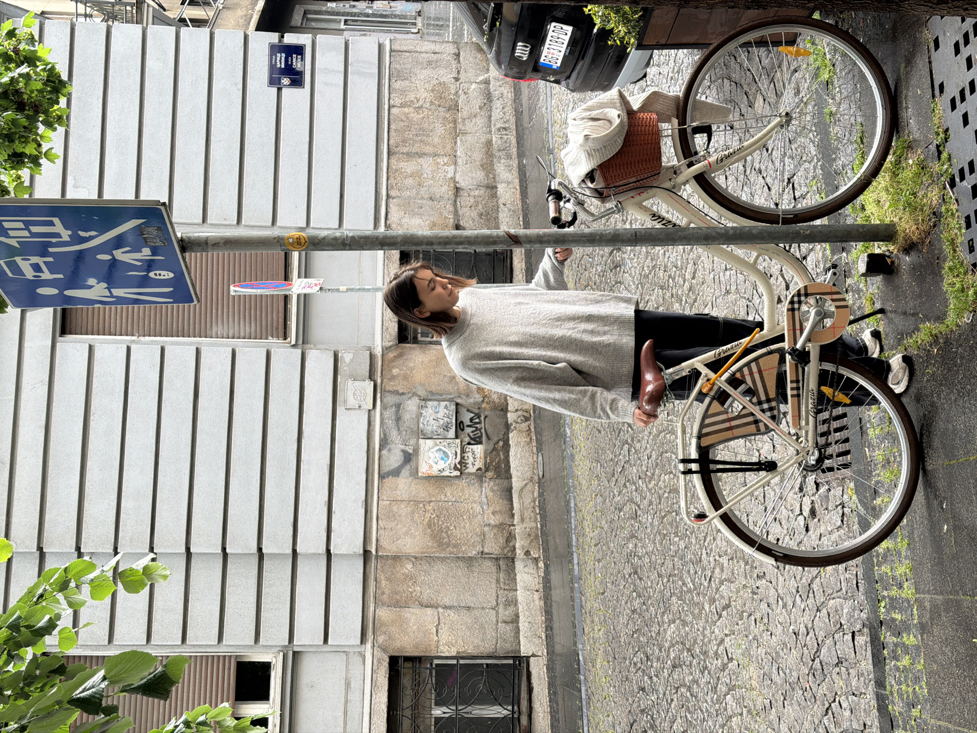 Woman with bicycle spotted on Belgrade cobblestone street