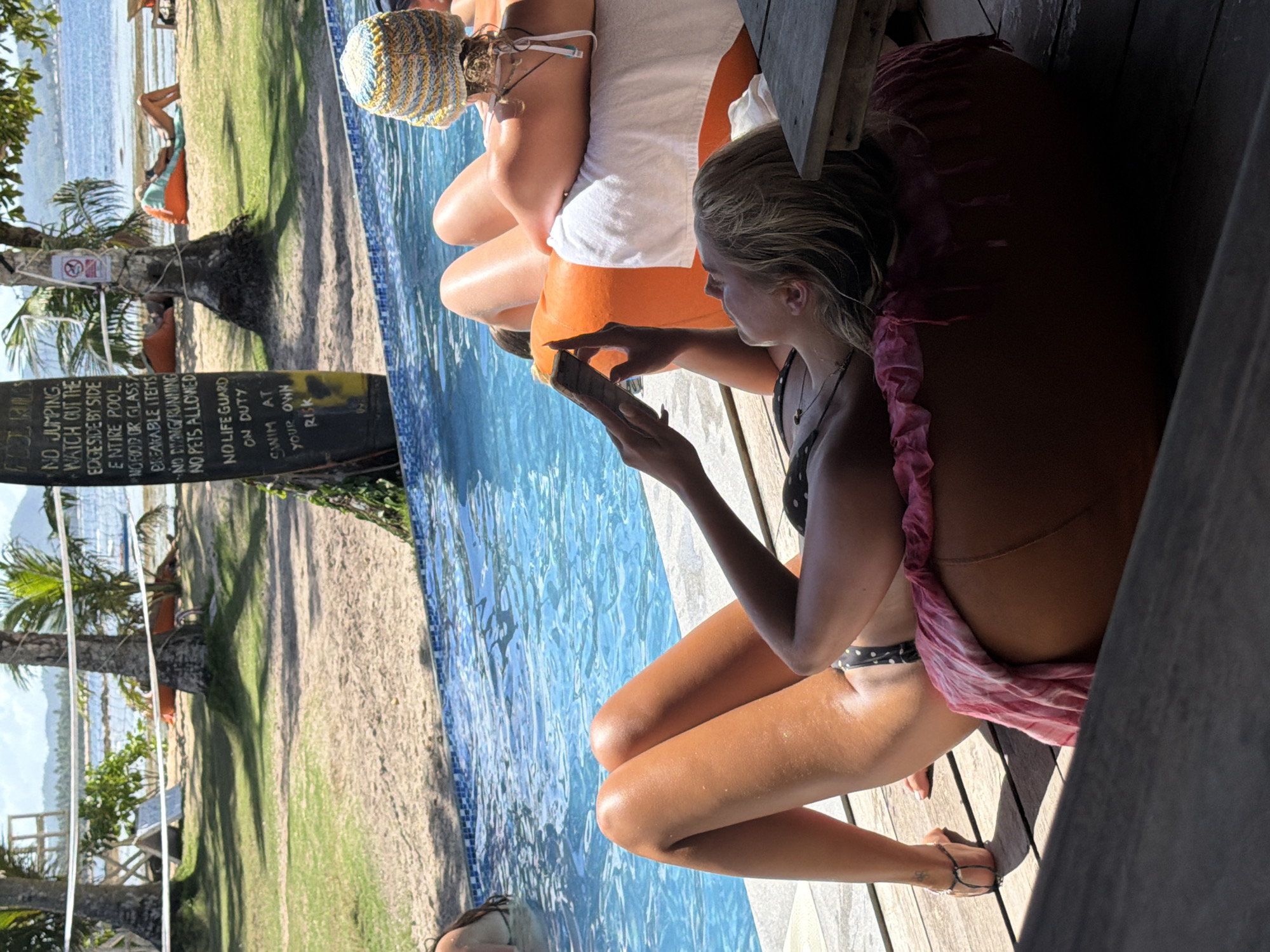 Two women relax poolside in General Luna, Philippines