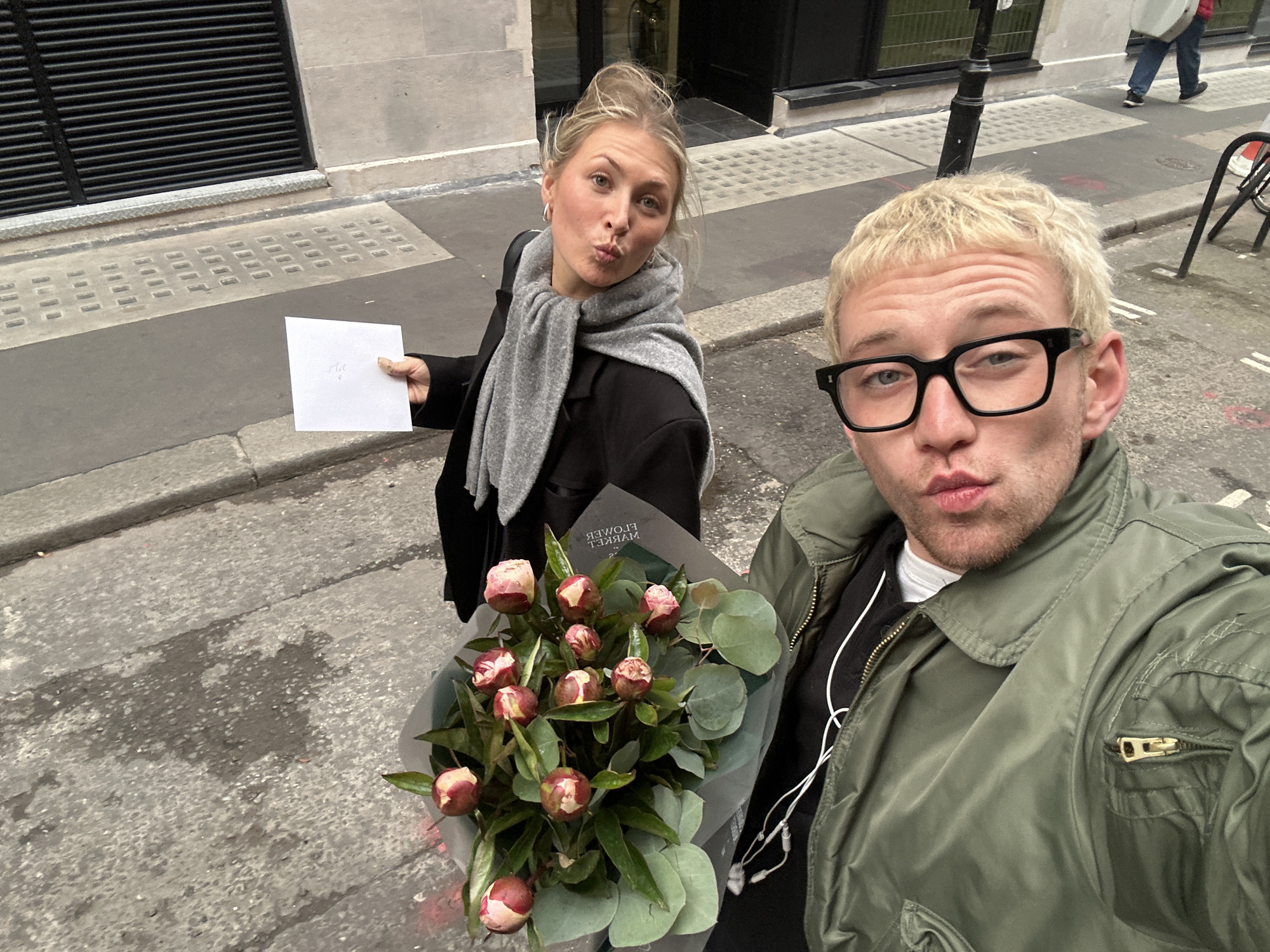 Two people with flowers and envelope observed on London street