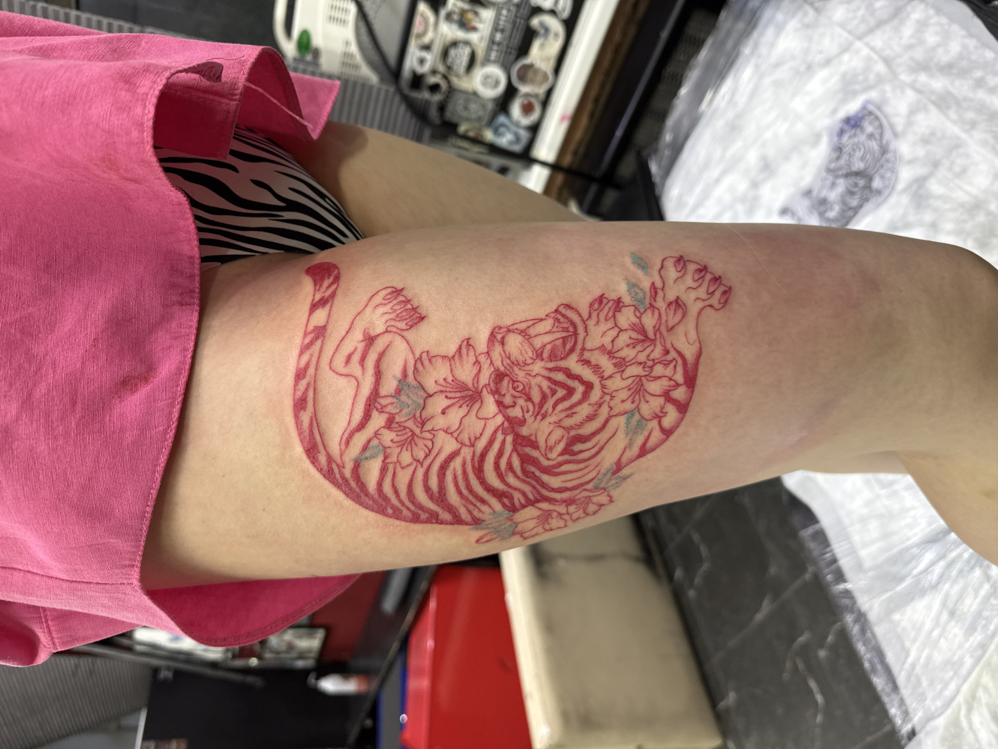 Fresh tattoo displayed on thigh in Moscow indoor setting