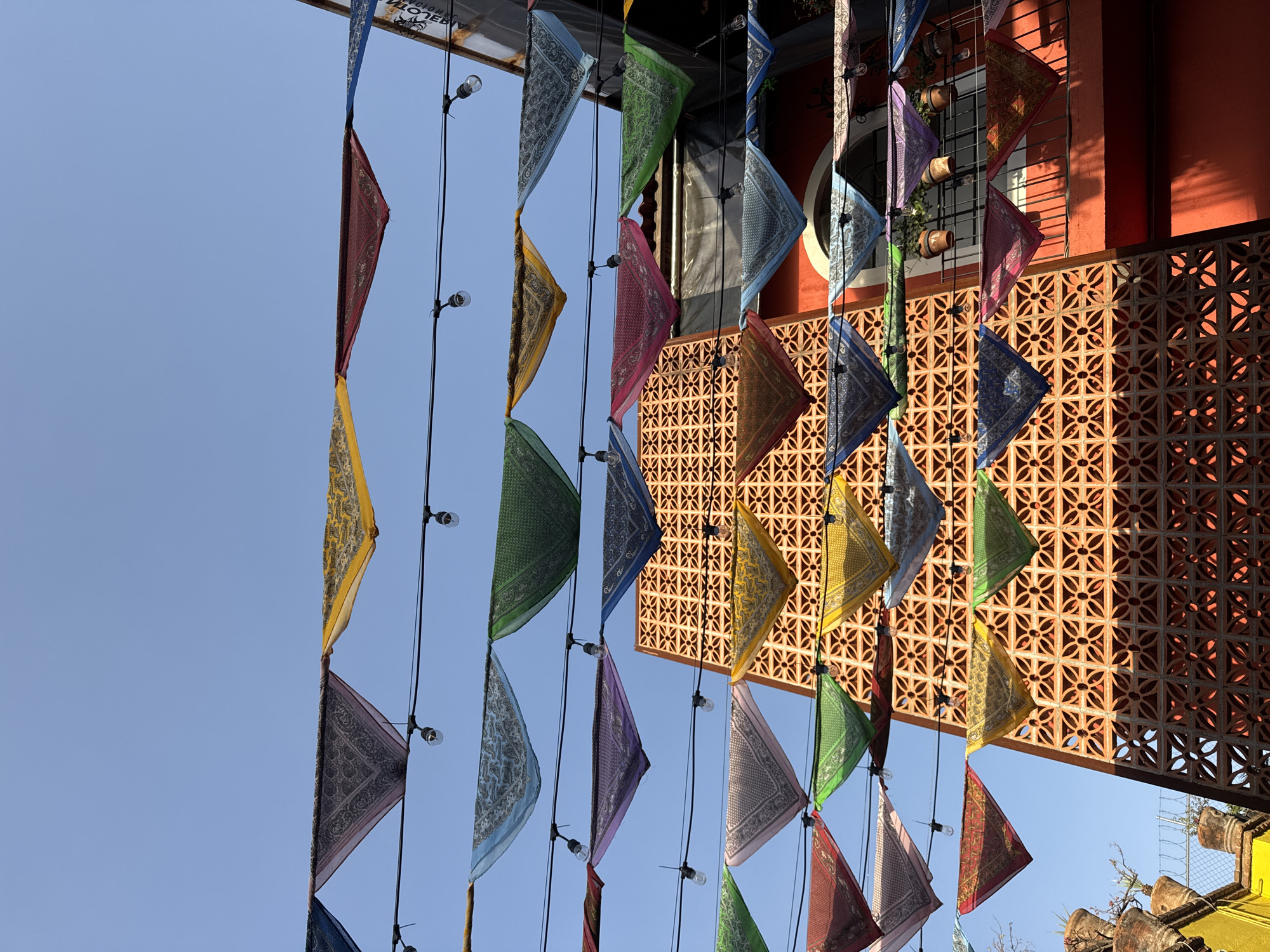 Colorful triangular flags captured hanging from lights in Puebla