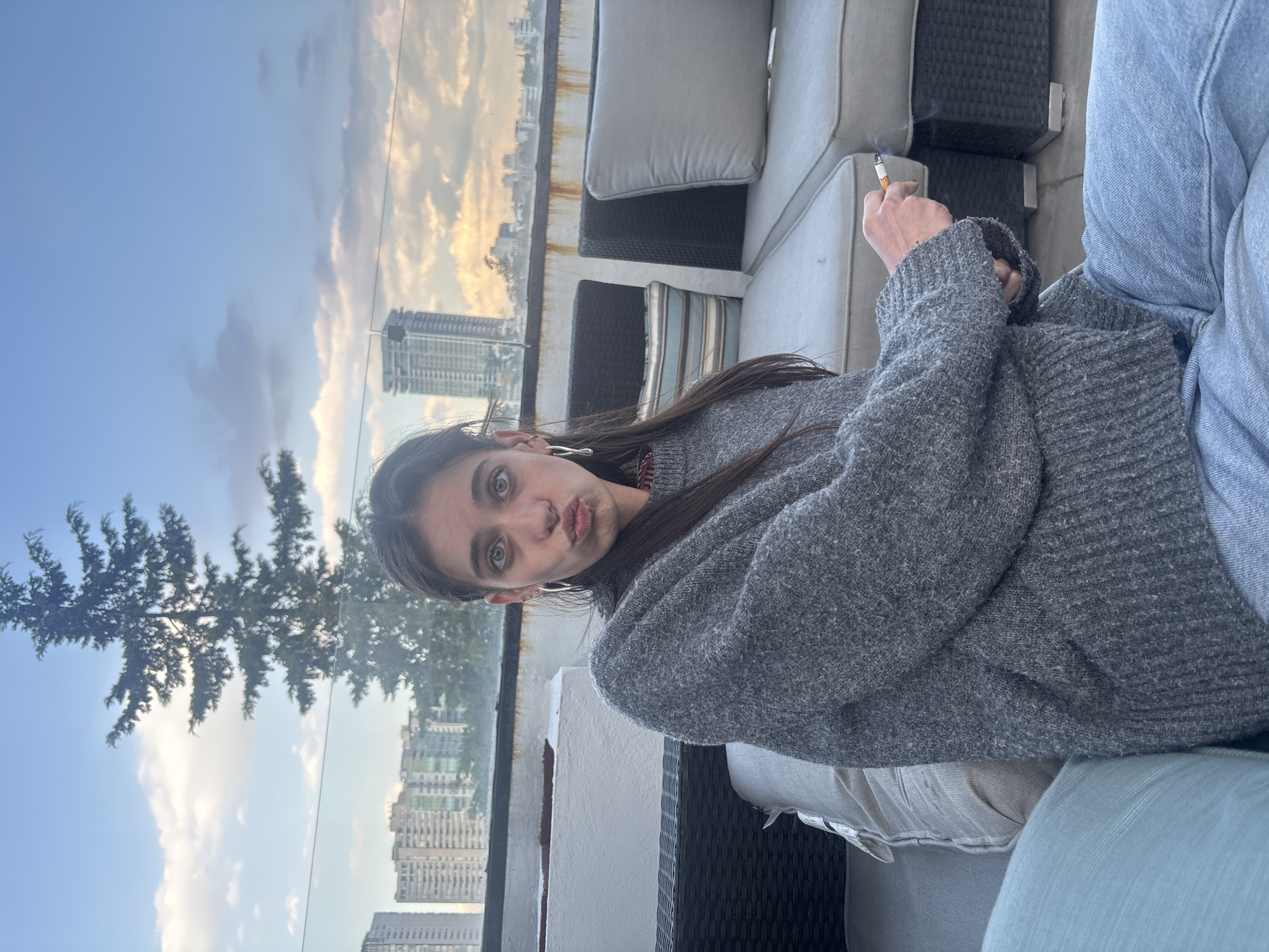 Woman relaxes on patio overlooking Mexico City skyline