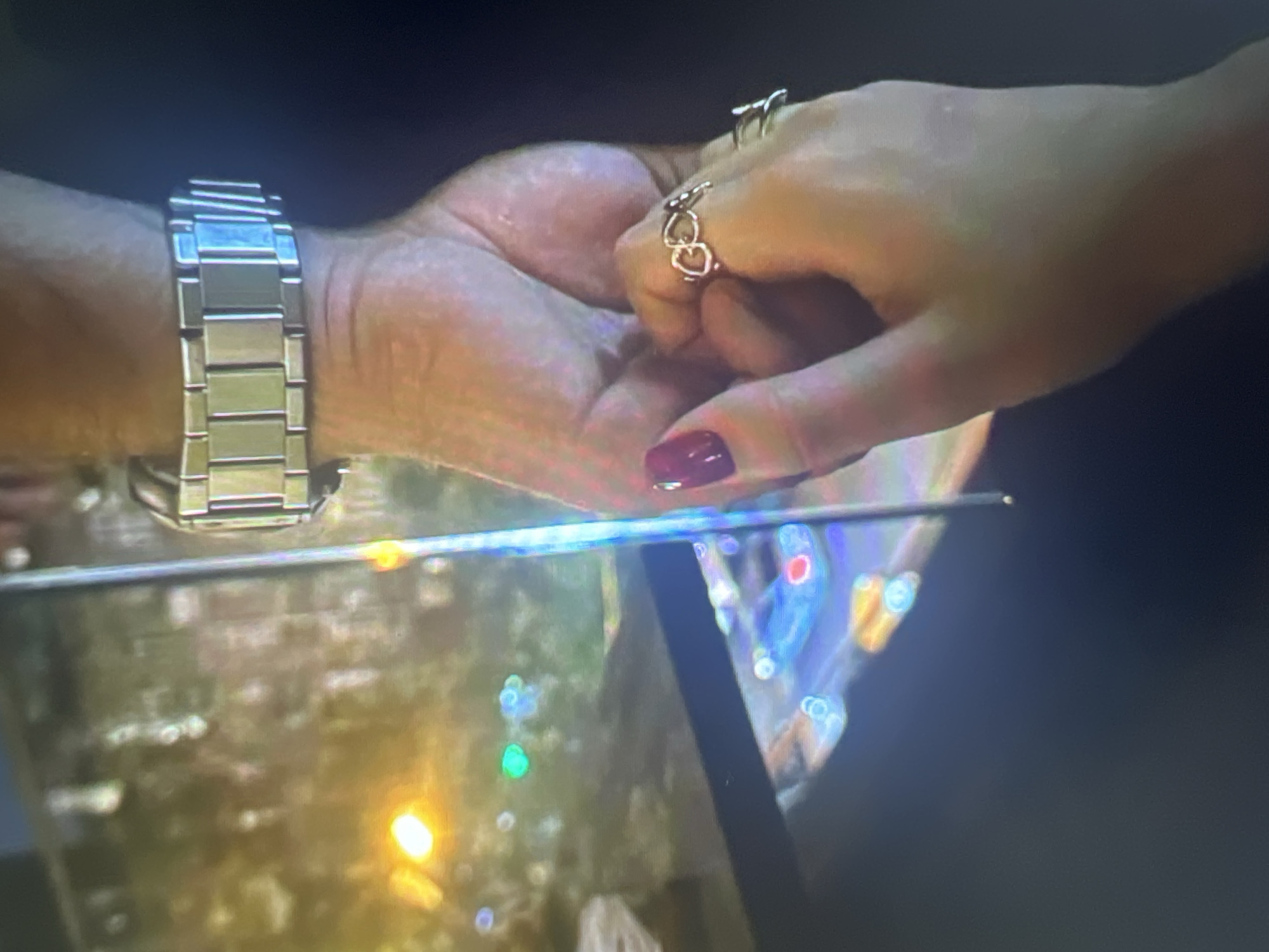 Hands holding and a betta fish drifting in a tank