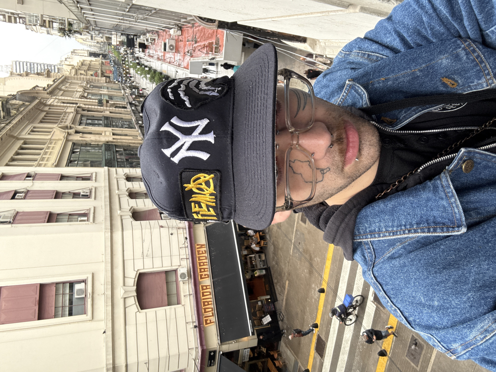 Person in denim jacket observed overlooking Buenos Aires street
