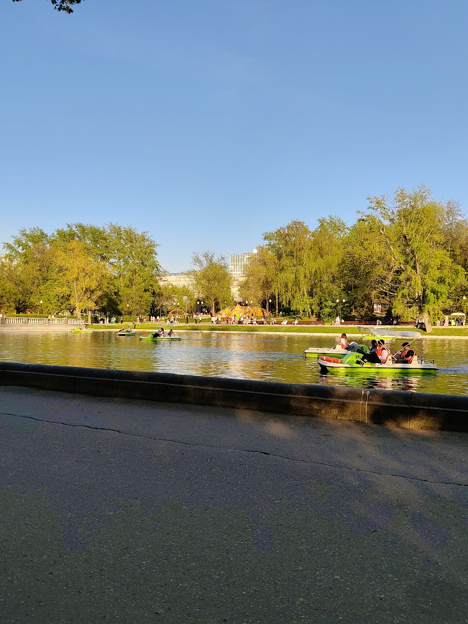 Moscow park bustles with pedal boats, cyclists on sunny afternoon