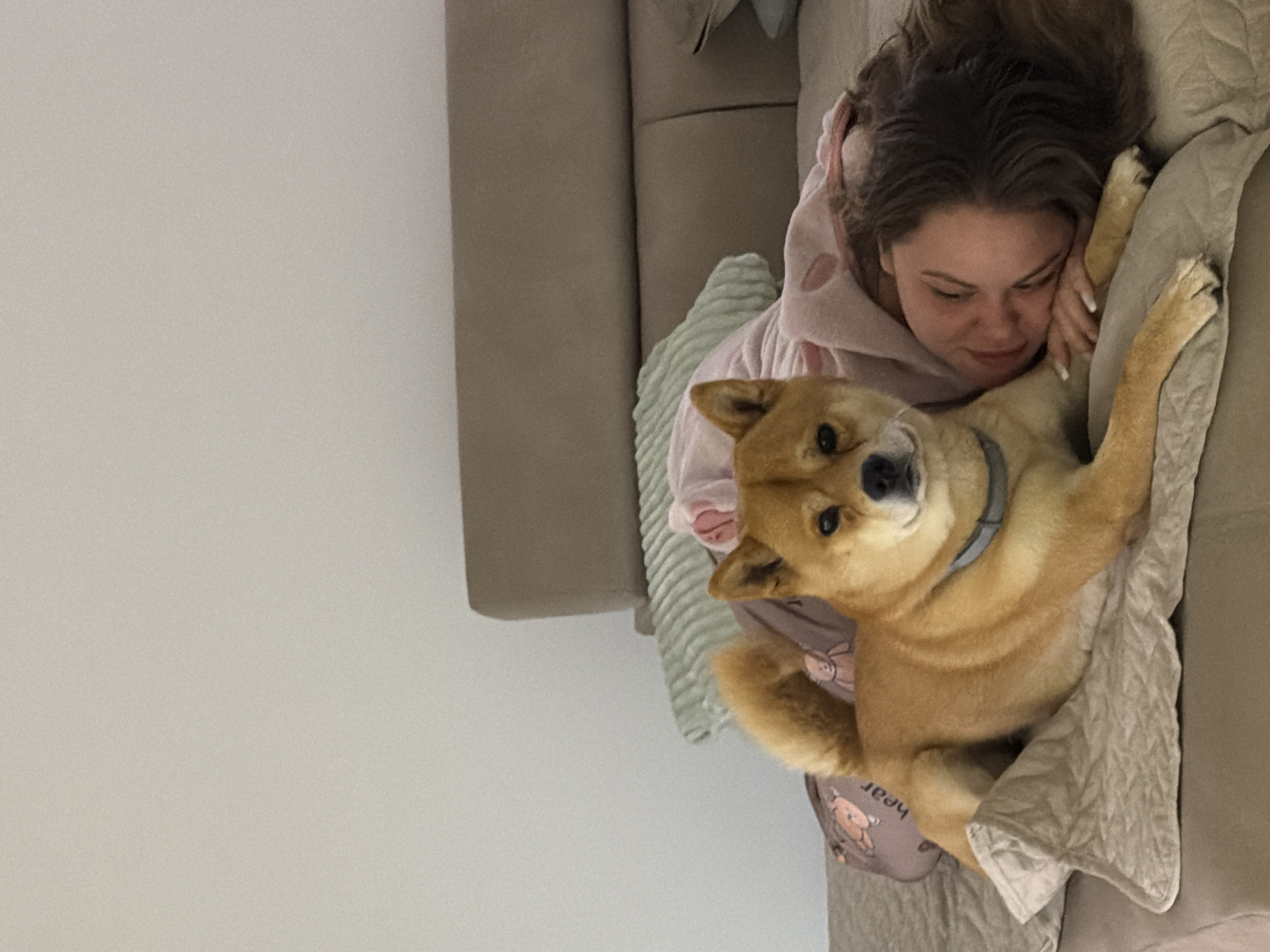 Woman and dog share quiet moment on sofa in Bulgaria