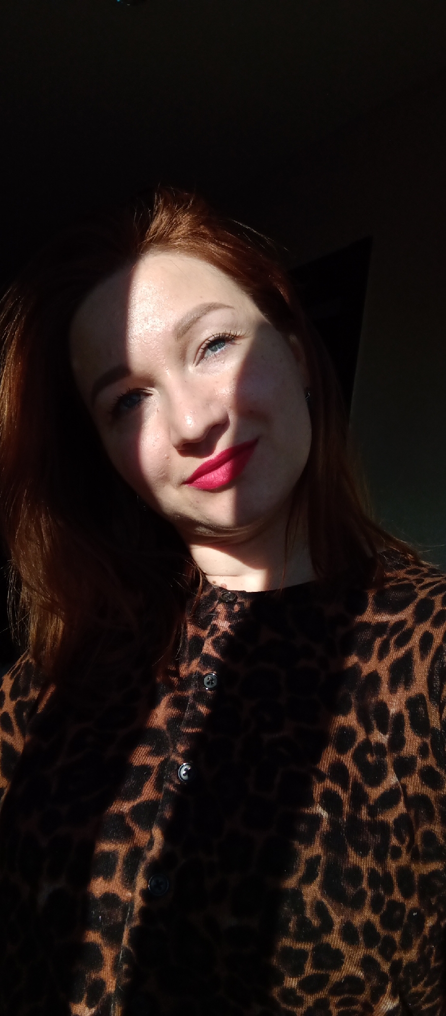 Red-haired woman photographed in leopard print with mango drink