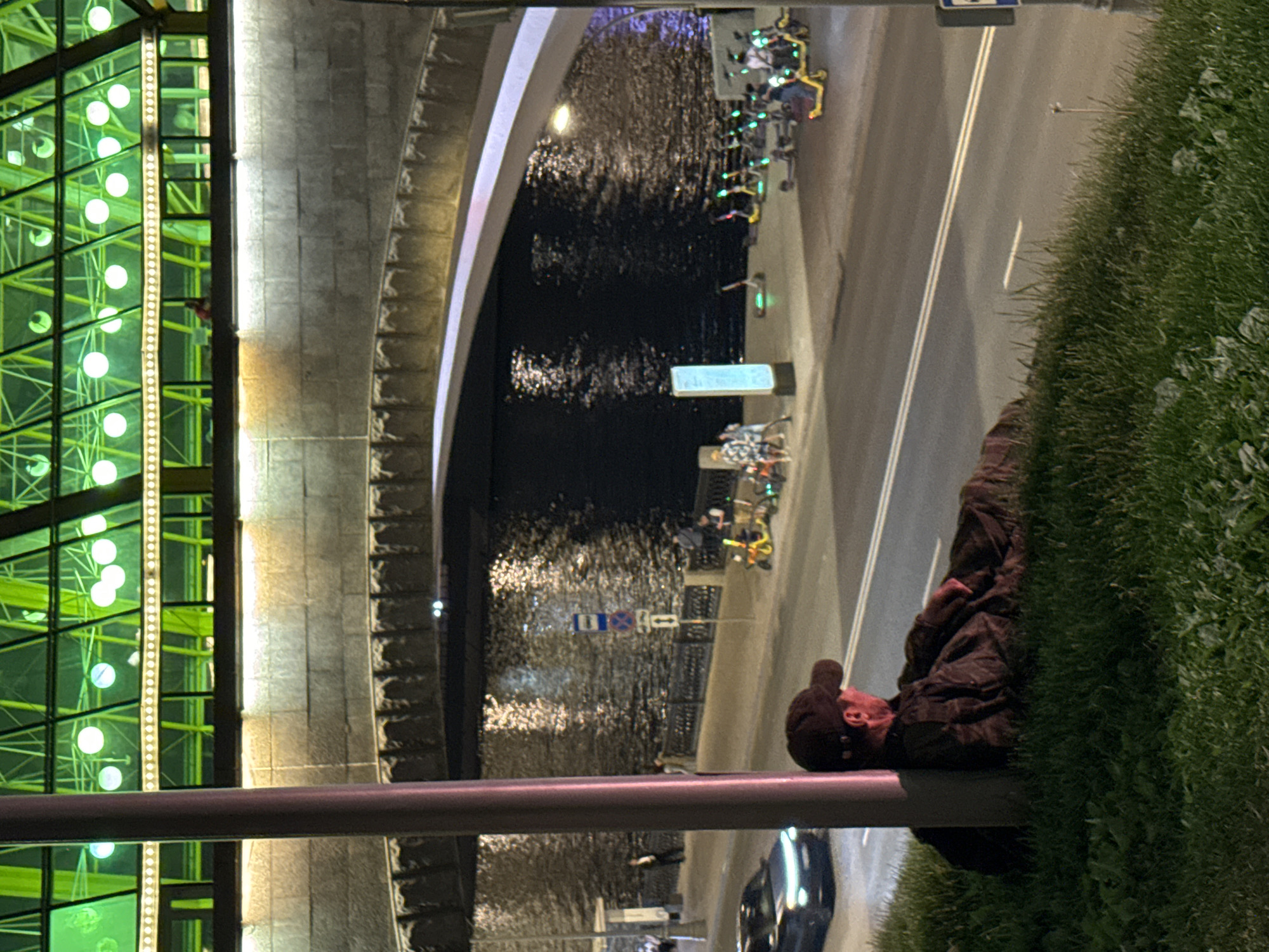 Man rests on Moscow riverbank embankment at night