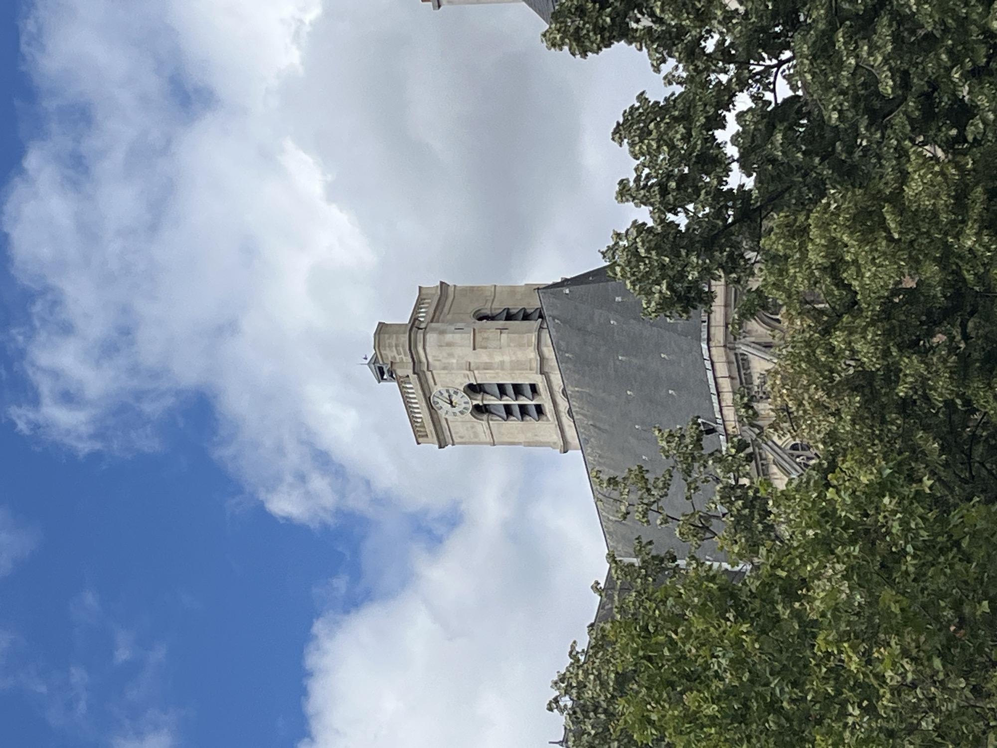 Gothic church tower and busy street life in central Paris