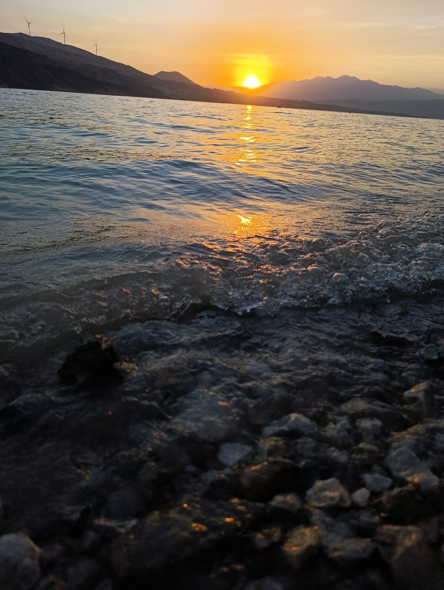 Sunset and jet skis at a mountain lake in Uzbekistan