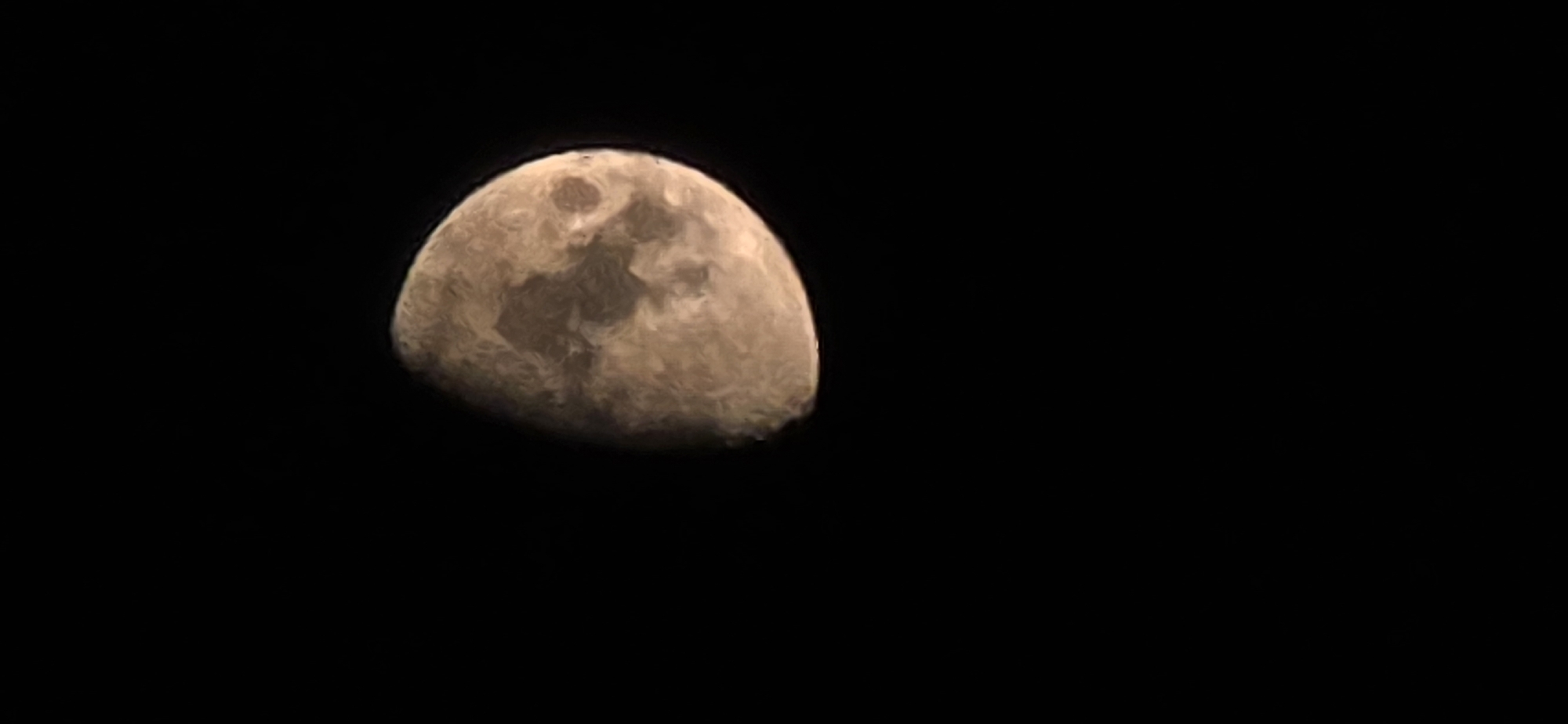 Partial moon with visible surface detail, shot from Tivat