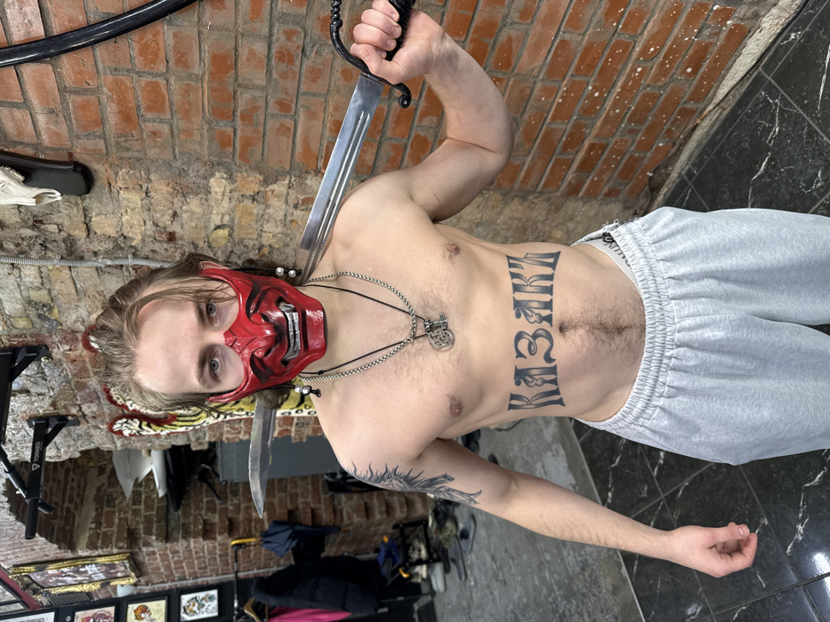 Masked individual with swords, tattoos photographed in Moscow