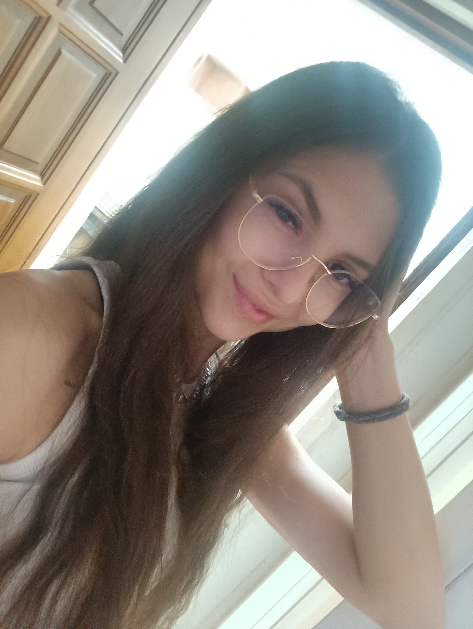 Woman takes indoor selfie near window early morning