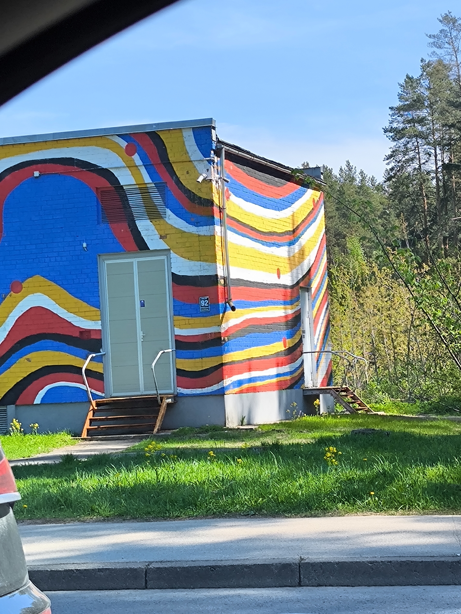 Colorful striped mural spotted on utility building in Riga