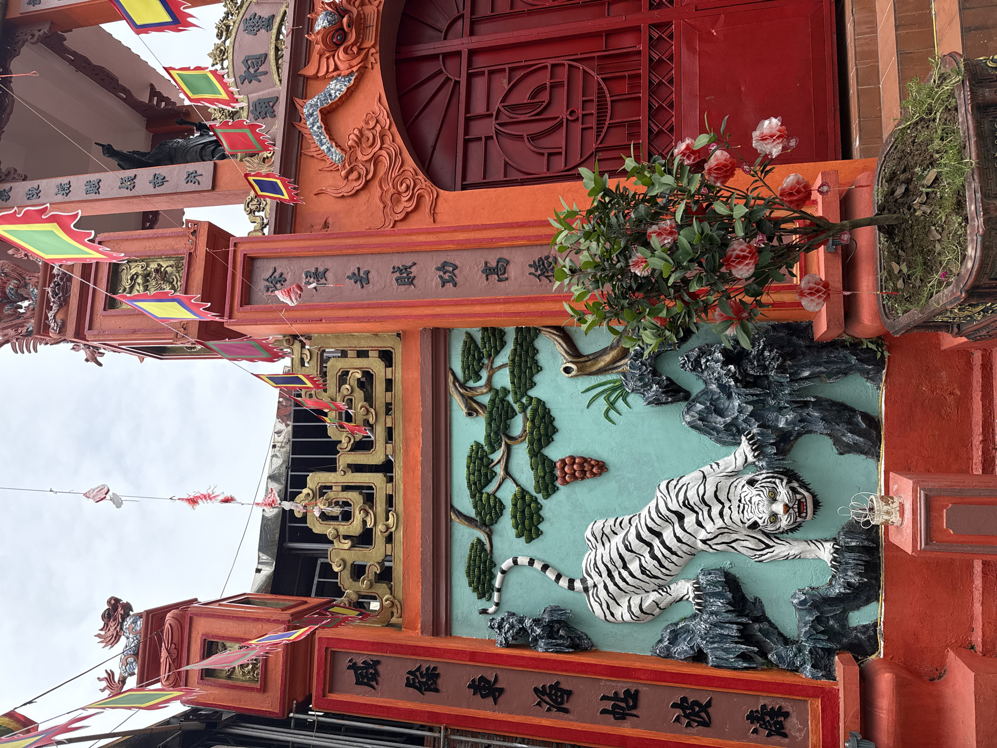 Temple gates and a coffee shop on the same Hanoi street