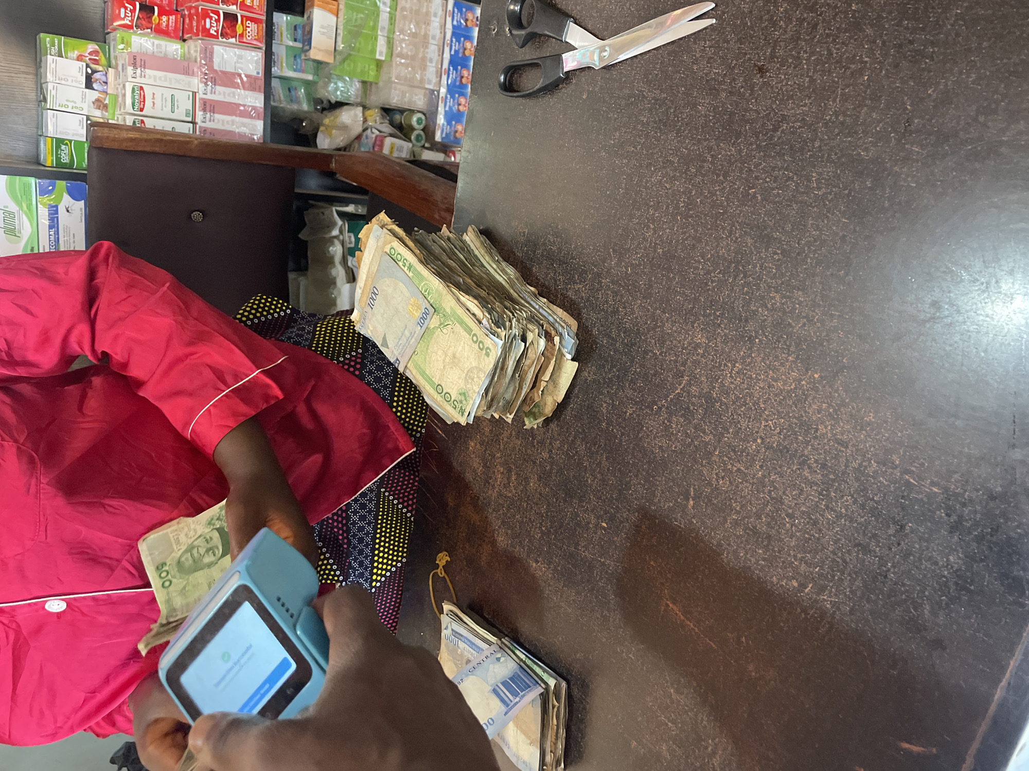 Person counts large sum of Naira currency at Nigerian shop