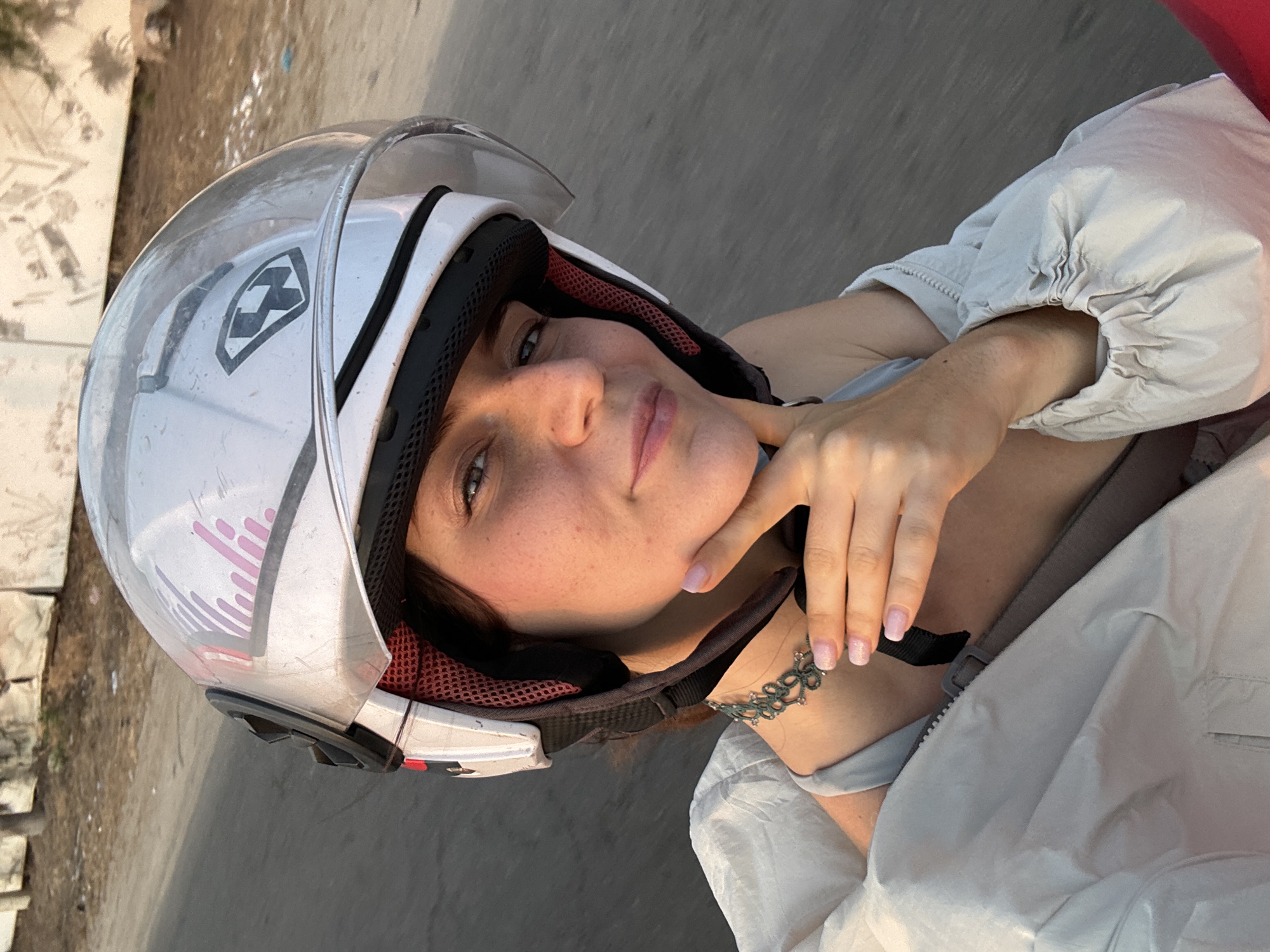 Woman in motorcycle helmet takes selfie in Mũi Né