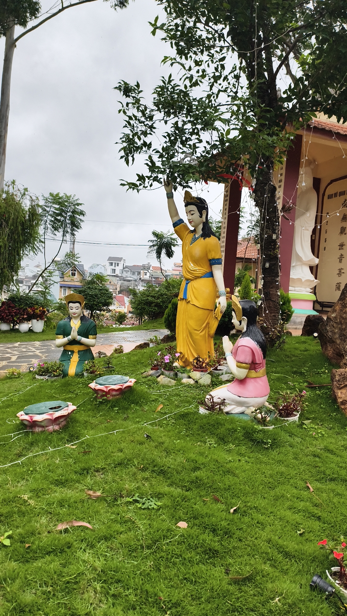 Buddhist temple grounds in Da Lat, statues and gardens in the rain