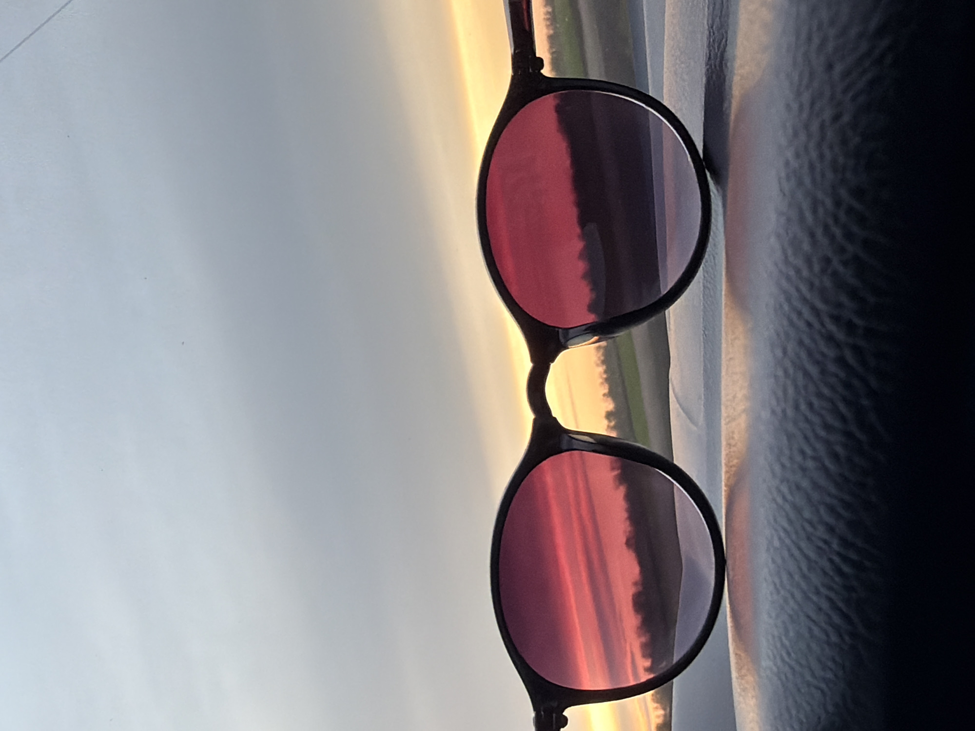 Rotated sunglasses reflect colorful sky in Alexandrovka, Russia
